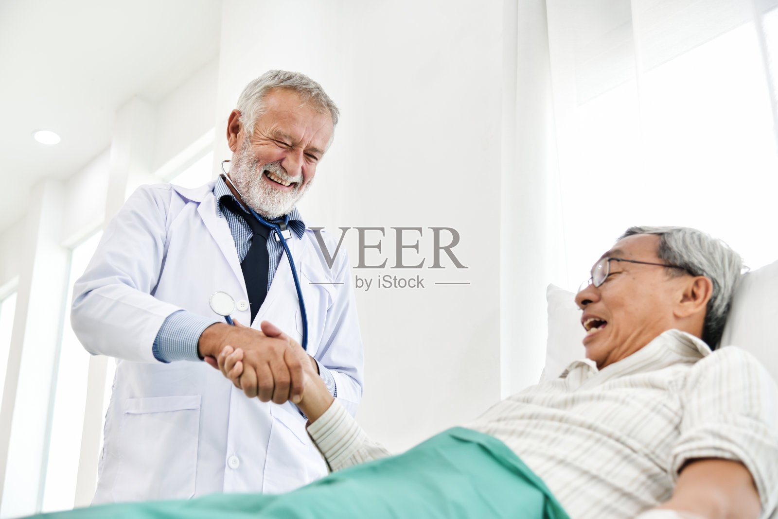 资深男医生正在与亚洲男性病人交谈。照片摄影图片