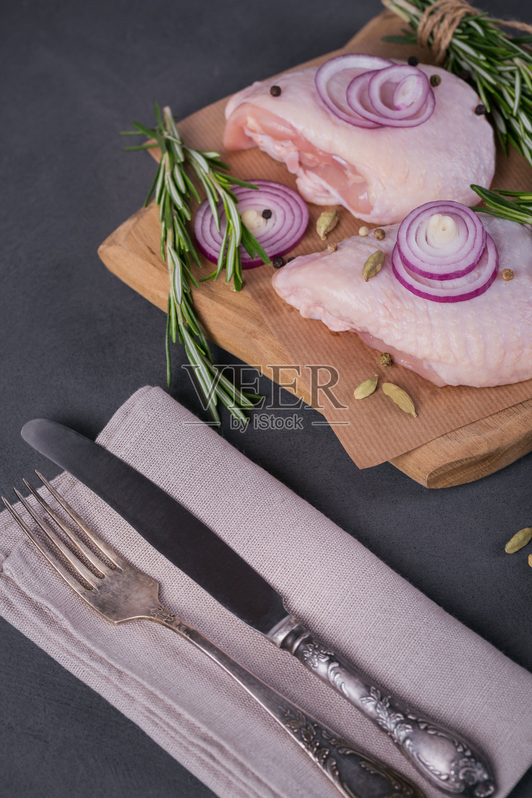 生鸡腿配迷迭香，红洋葱和花椒照片摄影图片