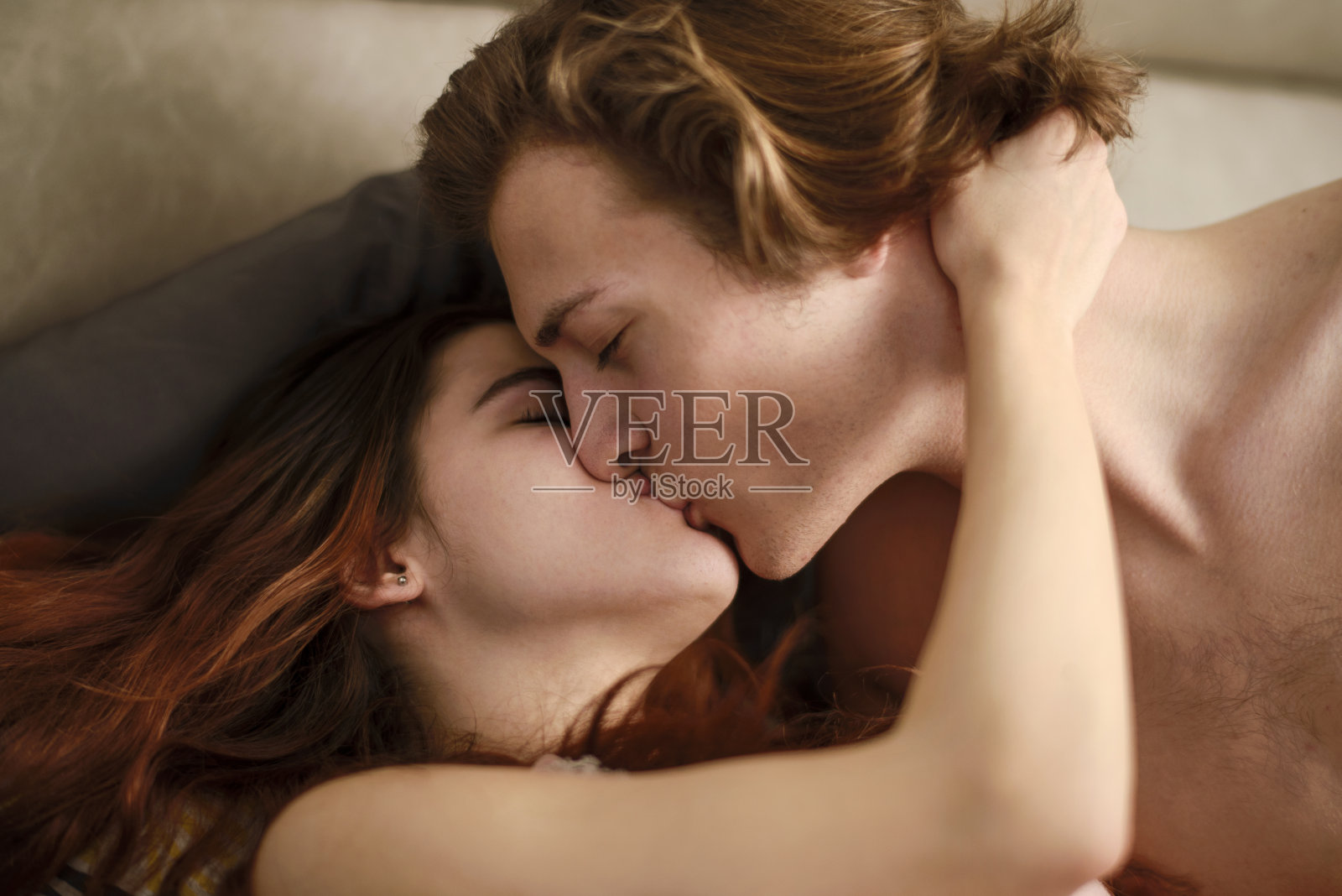 性感的年轻夫妇躺在床上的肖像照片摄影图片