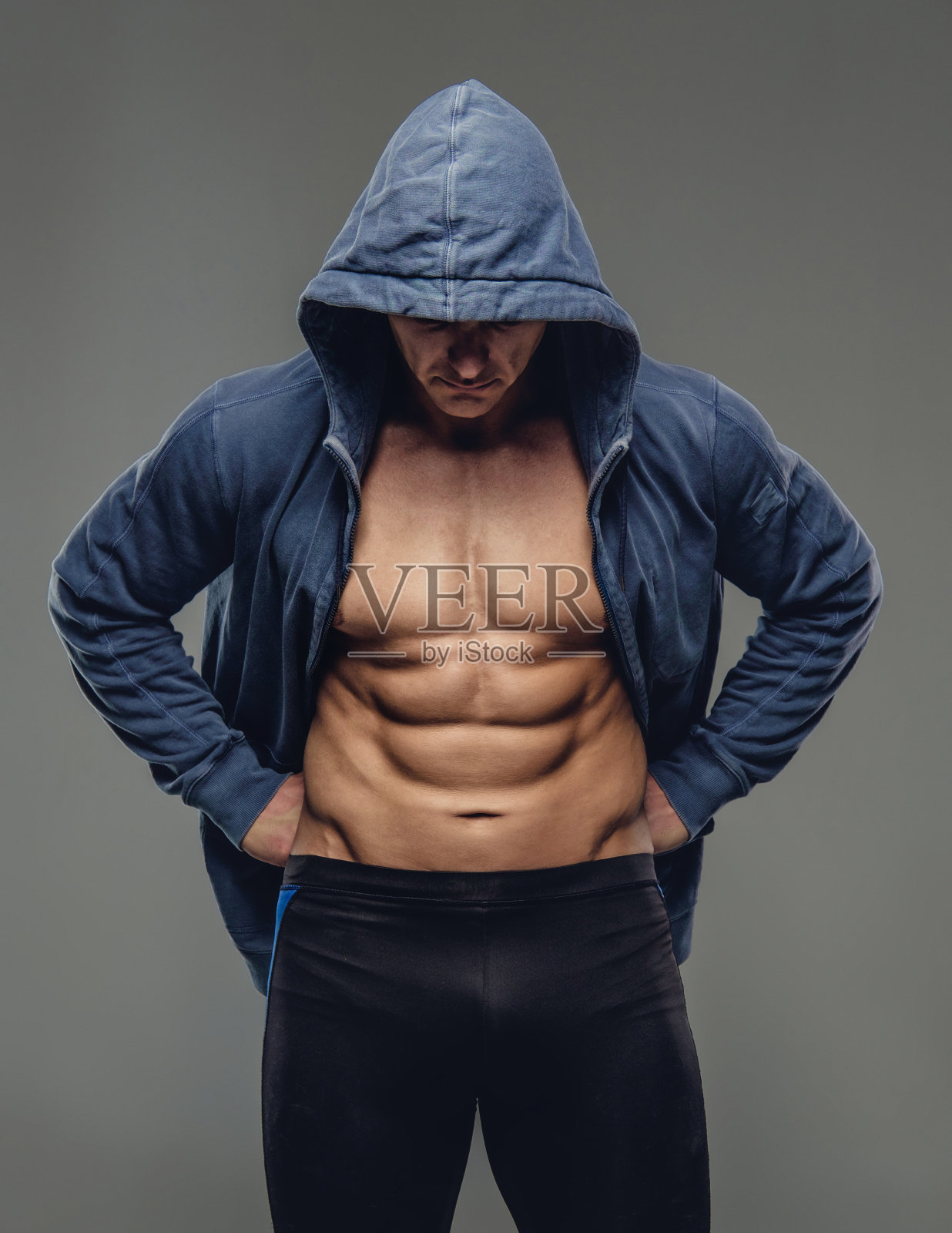 穿着蓝色连帽衫的腹部男人。照片摄影图片