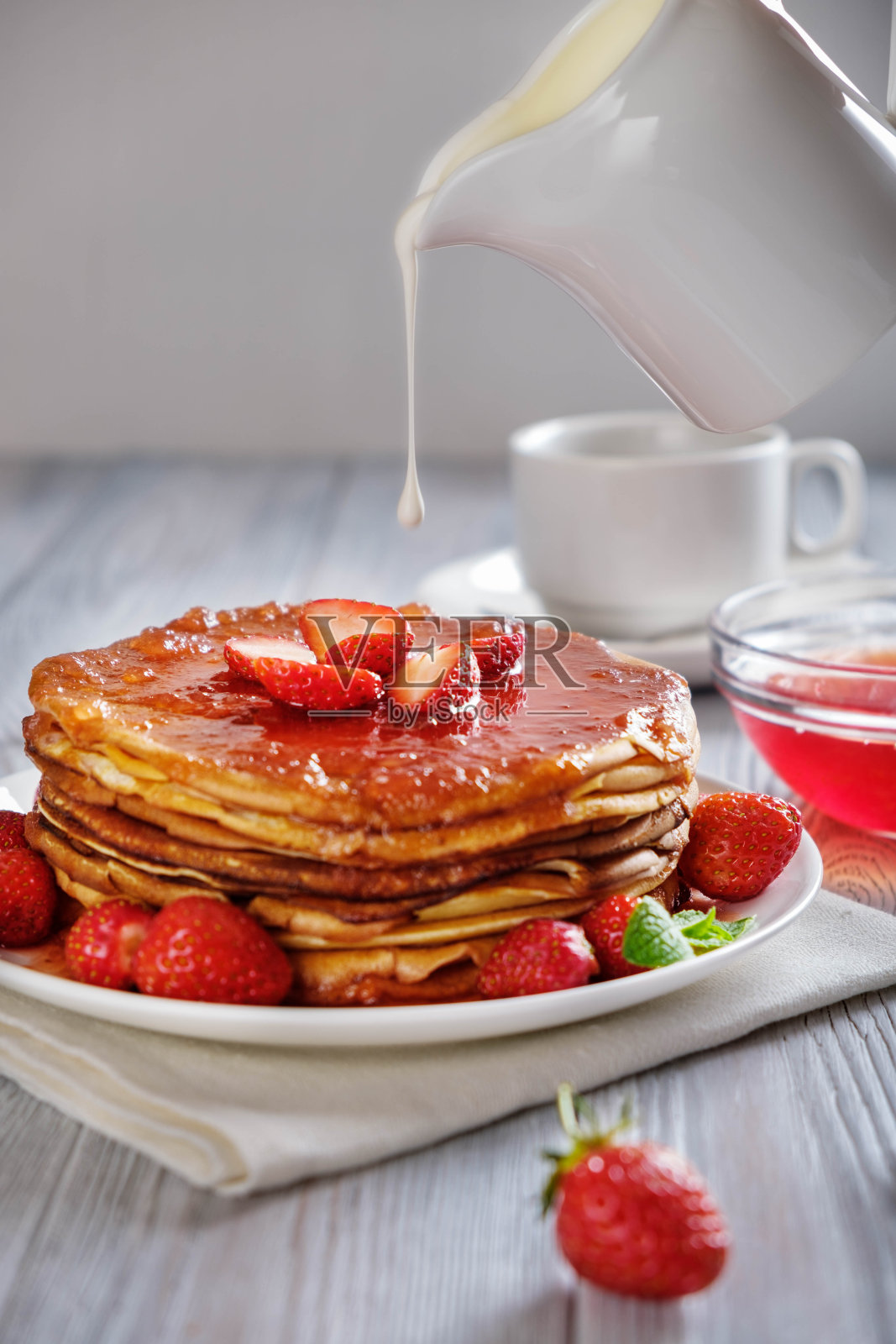 煎饼配新鲜的草莓和果酱。照片摄影图片