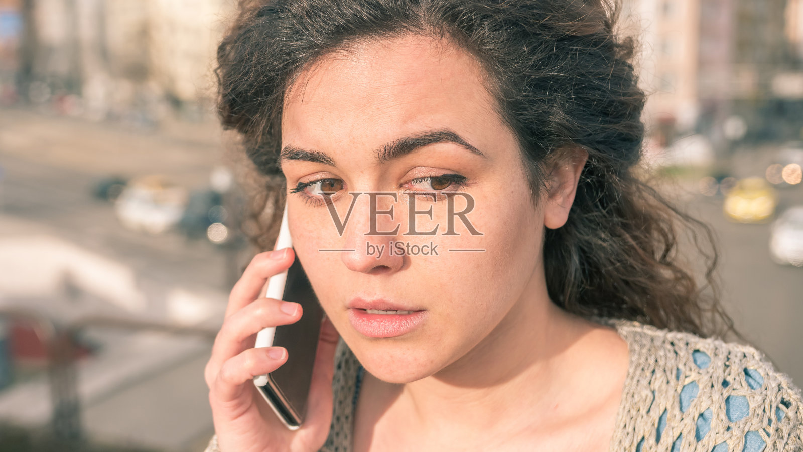 一个悲伤的女孩在户外打电话的特写照片摄影图片