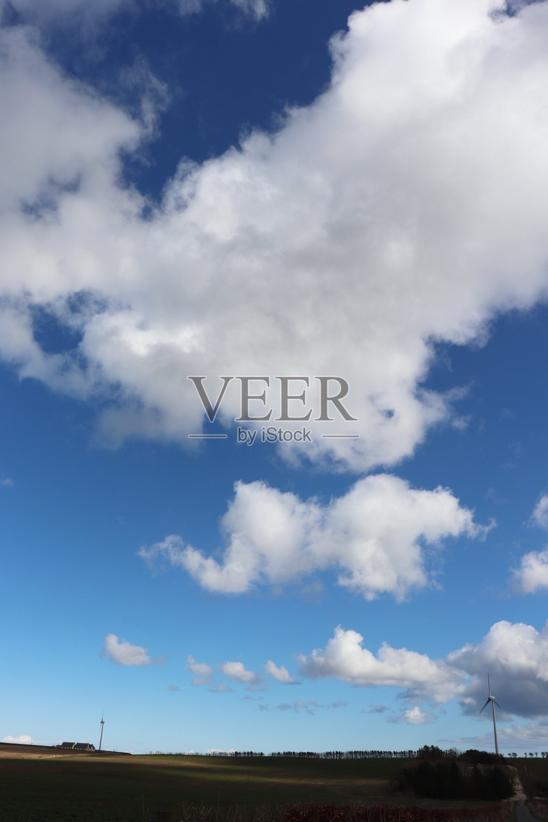 在乡村环境中，蓝天映衬着蓬松的白云，还有风力涡轮机或乡村公路照片摄影图片