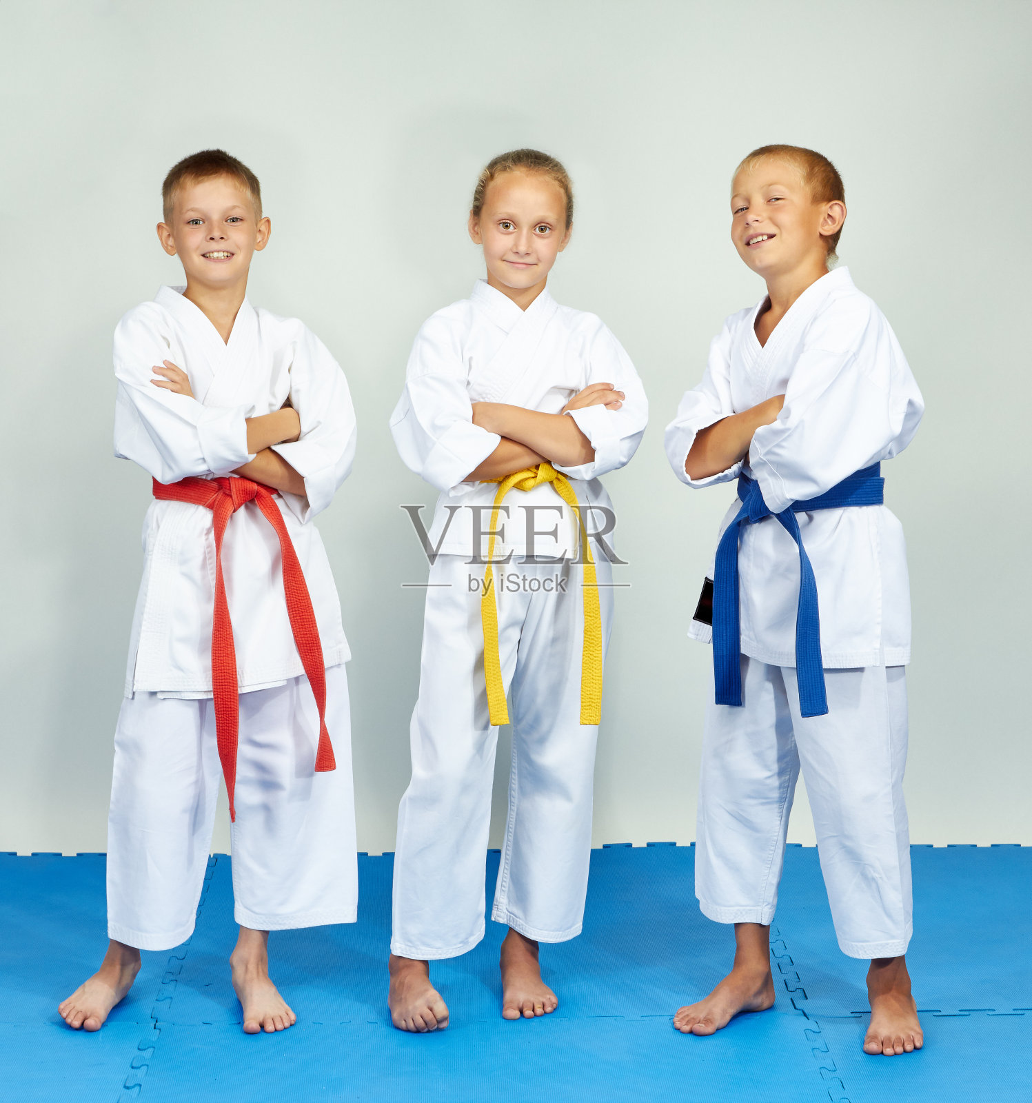 有趣的空手道运动员站在蓝色的垫子上照片摄影图片