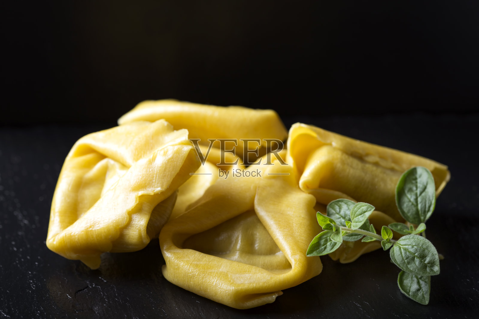 黑石板上塞满肉的生馄饨照片摄影图片