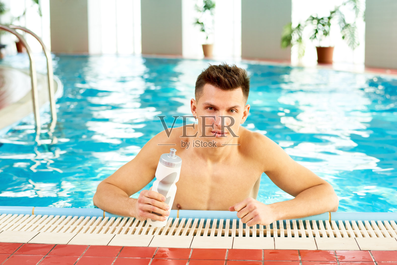 泳池里的帅哥照片摄影图片