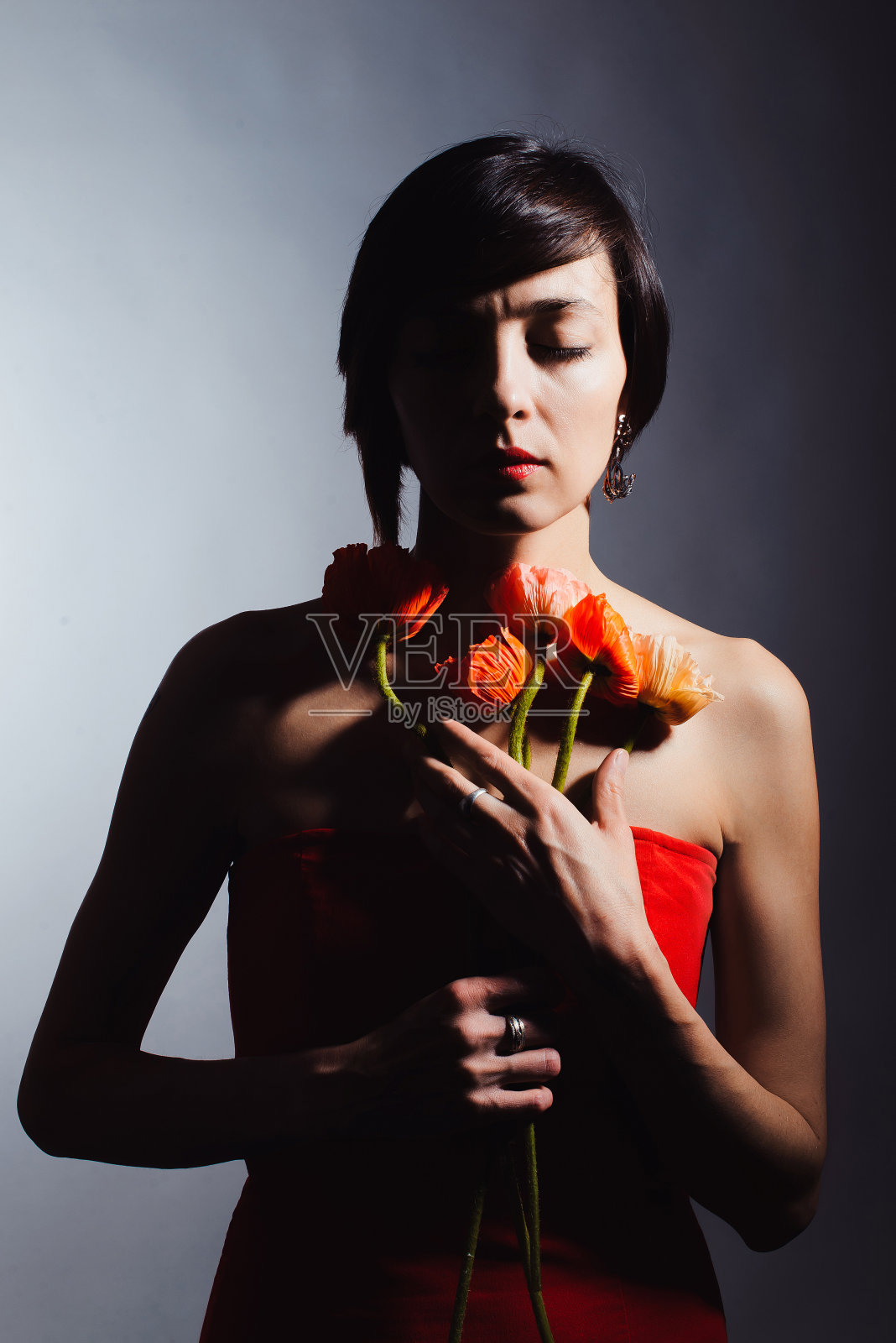 褐发女人穿着白色背景上有花的红色连衣裙照片摄影图片