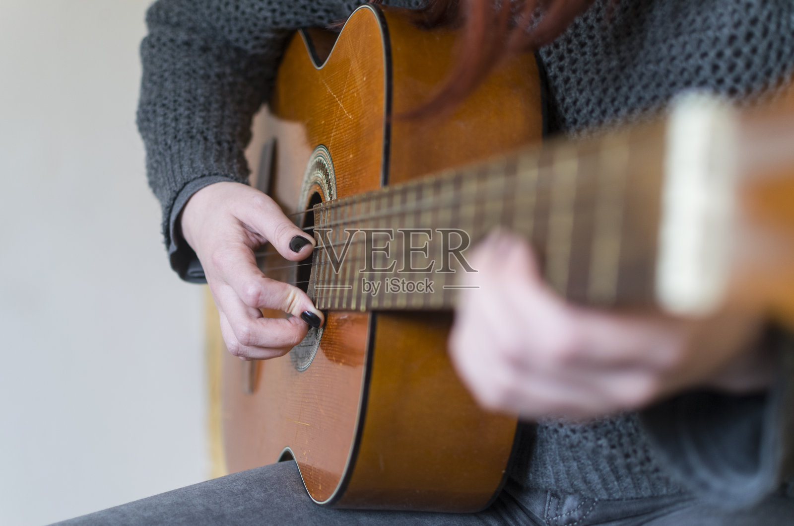 女人的手在弹原声吉他。有选择性的重点照片摄影图片