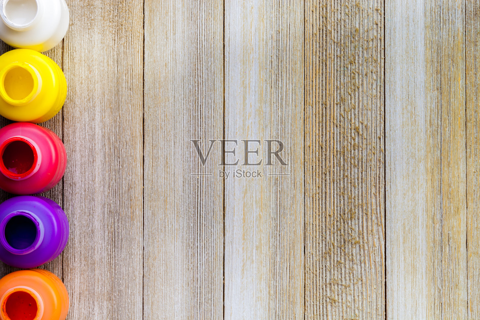 一排彩色的颜料瓶在质朴的木制背景与复制空间，俯视图/艺术和工艺品背景概念照片摄影图片