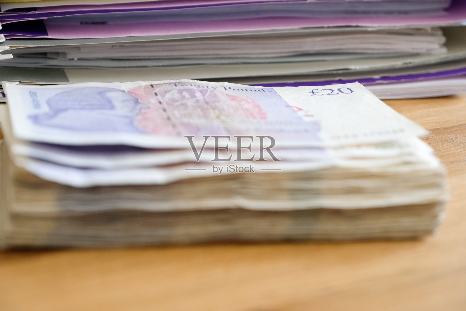 一堆二十英镑的钞票现金收入在一堆税务文件前照片摄影图片