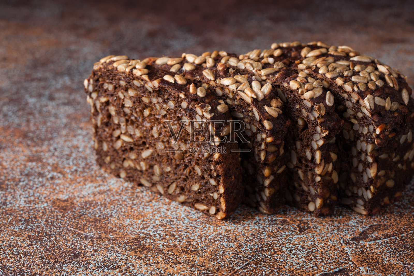 生锈的旧桌子上放着新鲜的黑面包和葵花籽照片摄影图片