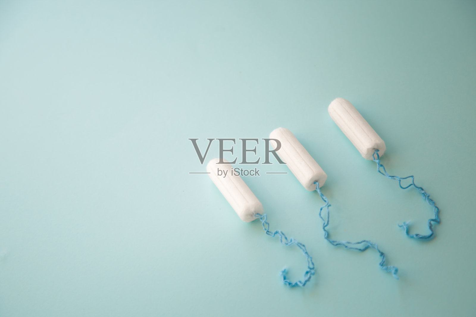 蓝色背景俯视图上的月经卫生棉条。文本。照片摄影图片