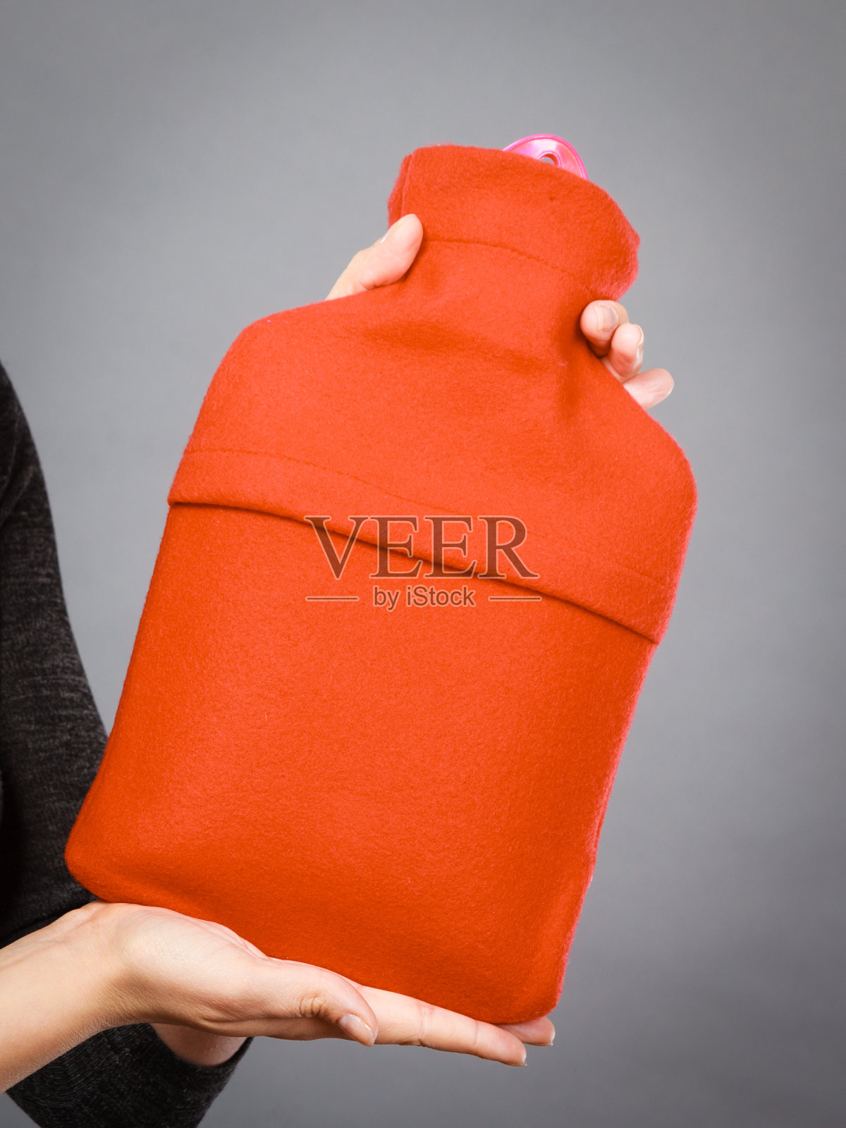 一个女人拿着一个用红色羊毛盖着的热水瓶照片摄影图片