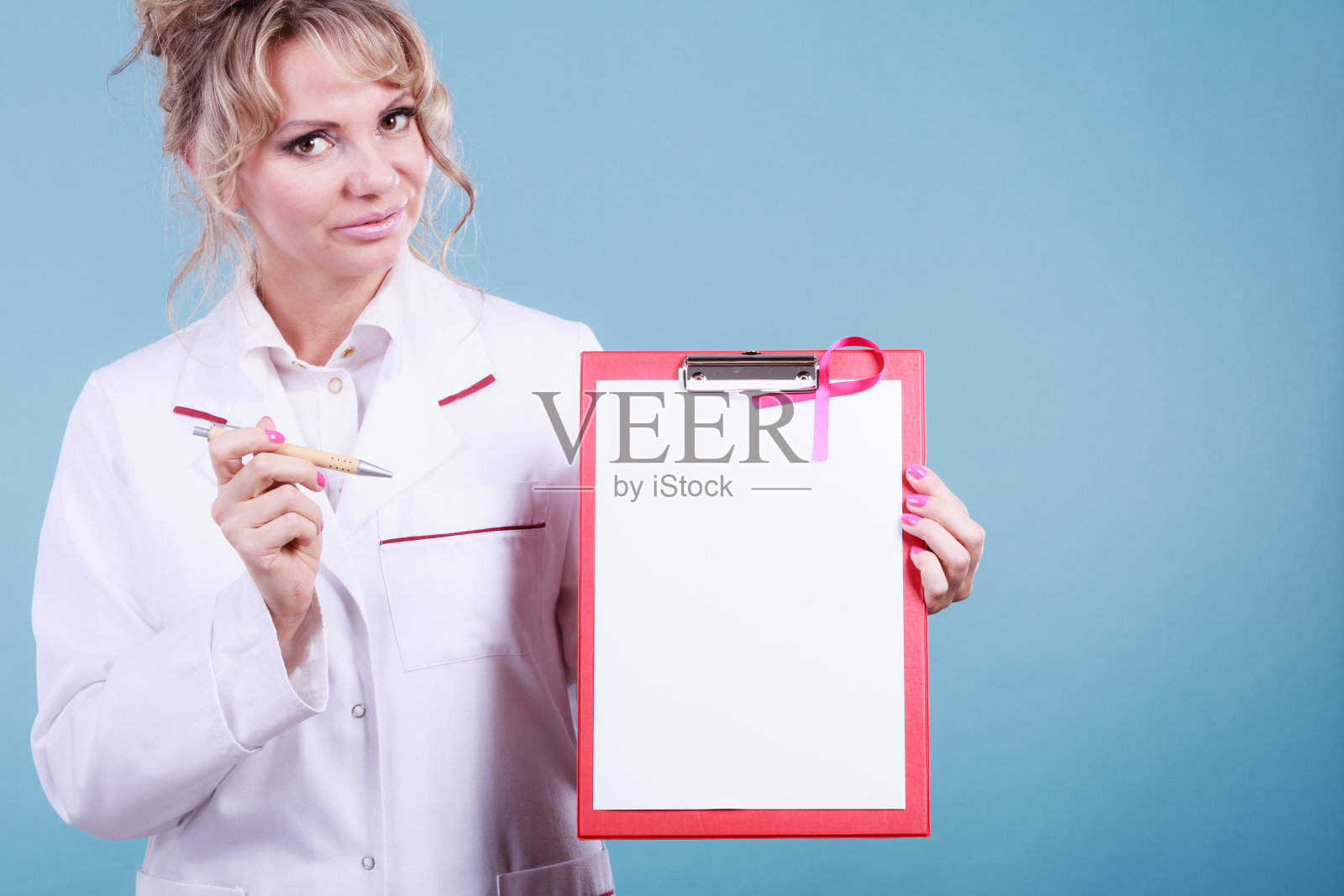 医生用钢笔展示带有粉红色丝带的文件夹。照片摄影图片