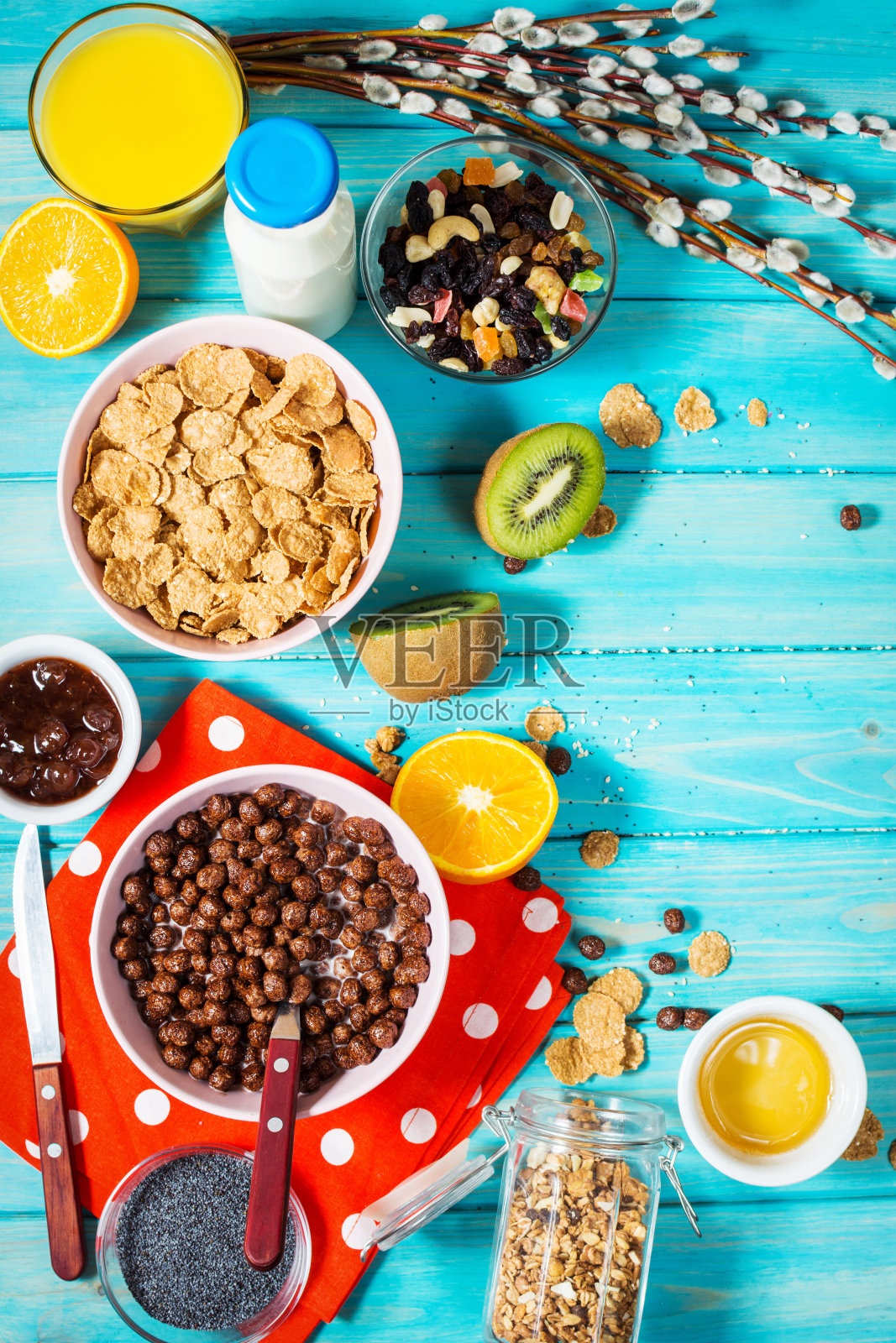 健康早餐一碗麦片，橙汁，格兰诺拉麦片，牛奶，果酱和水果在蓝色的木头背景。均衡的饮食。照片摄影图片