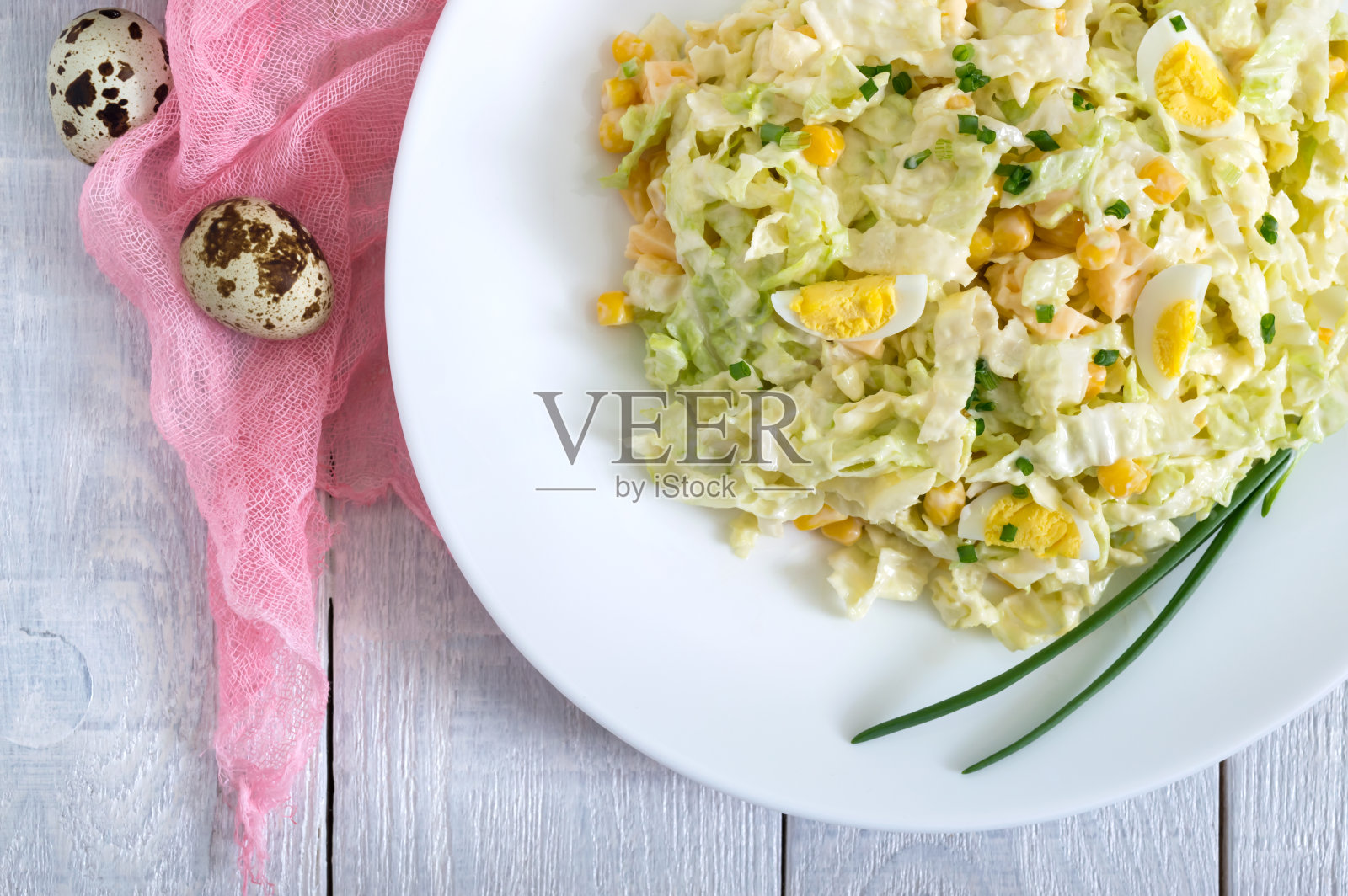 清淡的春季饮食沙拉，由白菜，奶酪，鹌鹑蛋，玉米。适当的营养。前视图。照片摄影图片