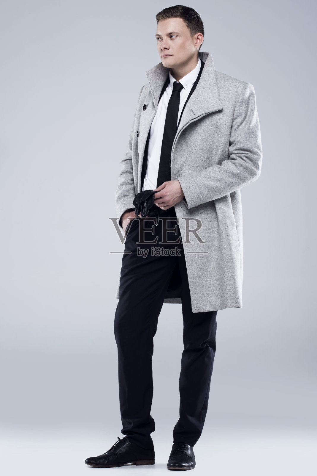 穿着灰色外套和黑色西装的英俊年轻人照片摄影图片