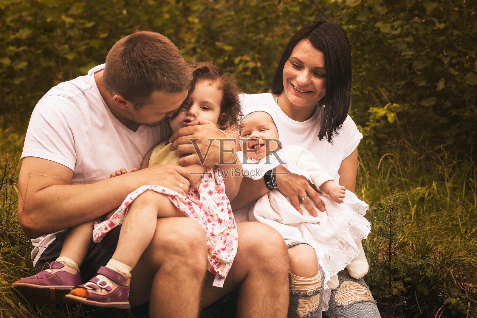 快乐的父母和两个孩子一起，在户外照片摄影图片