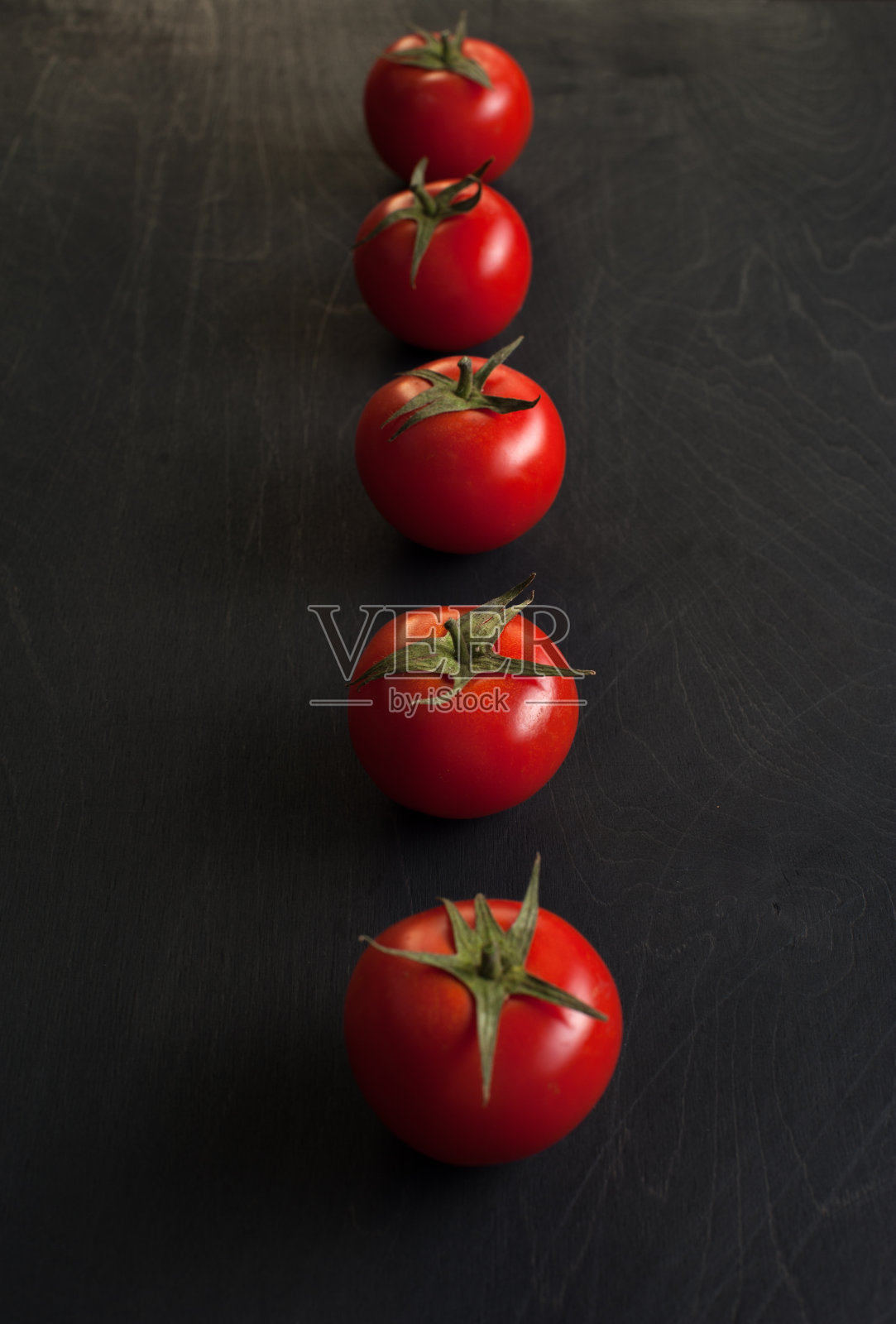 深色背景上的一排樱桃番茄照片摄影图片