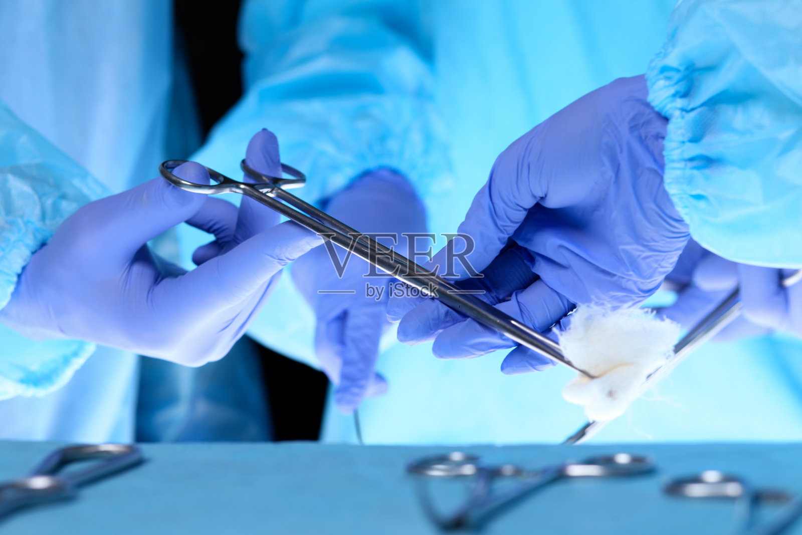 外科医生手握手术剪刀，传递手术设备，特写。保健和兽医概念照片摄影图片