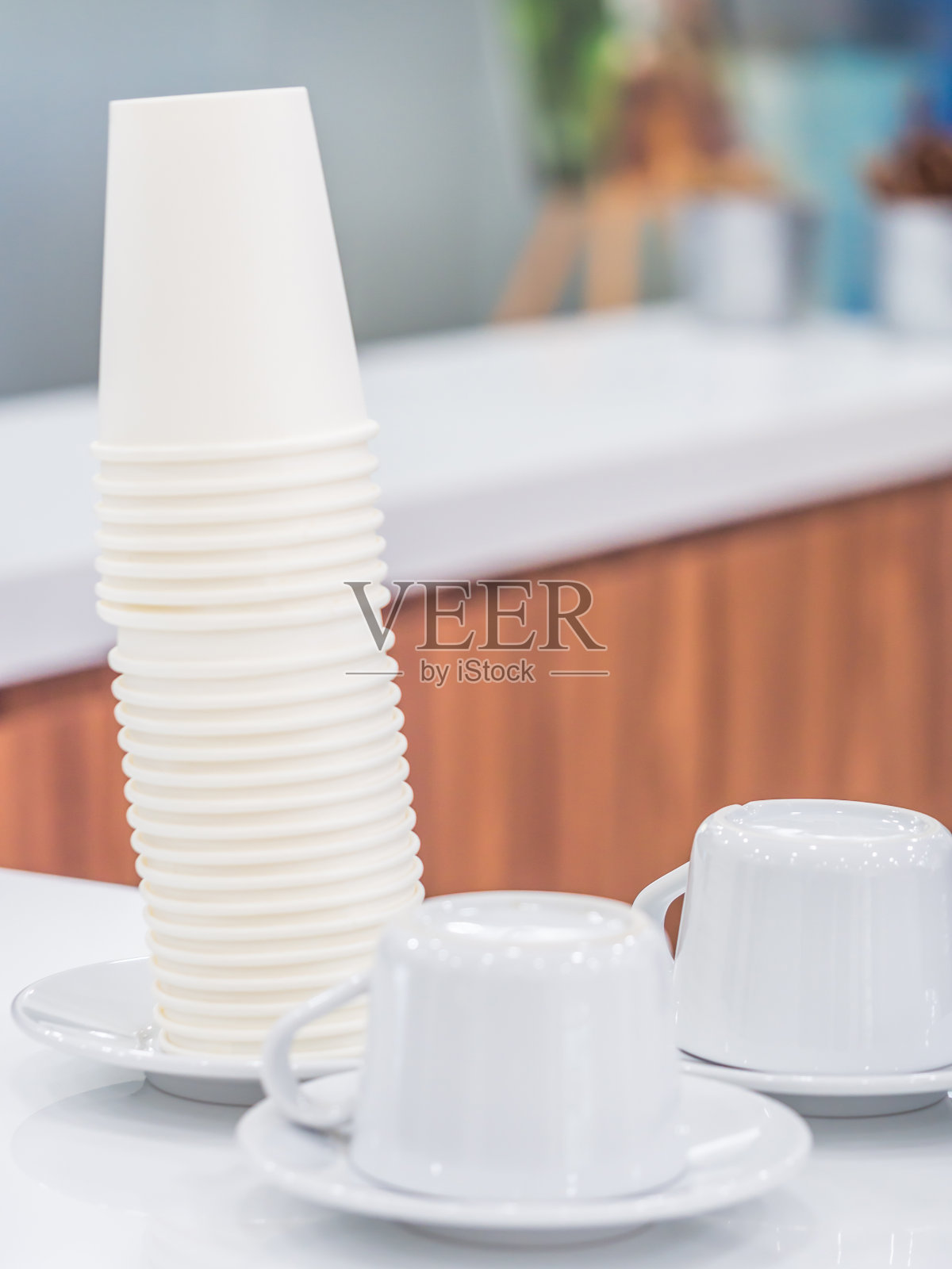 把纸杯和咖啡杯倒放在桌子上。照片摄影图片