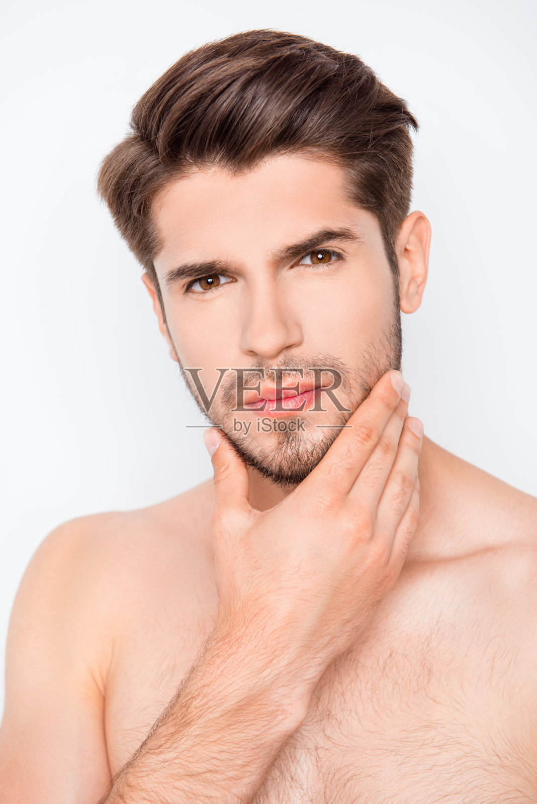 英俊的大胡子男子抚摸着脸准备刮胡子的肖像照片摄影图片