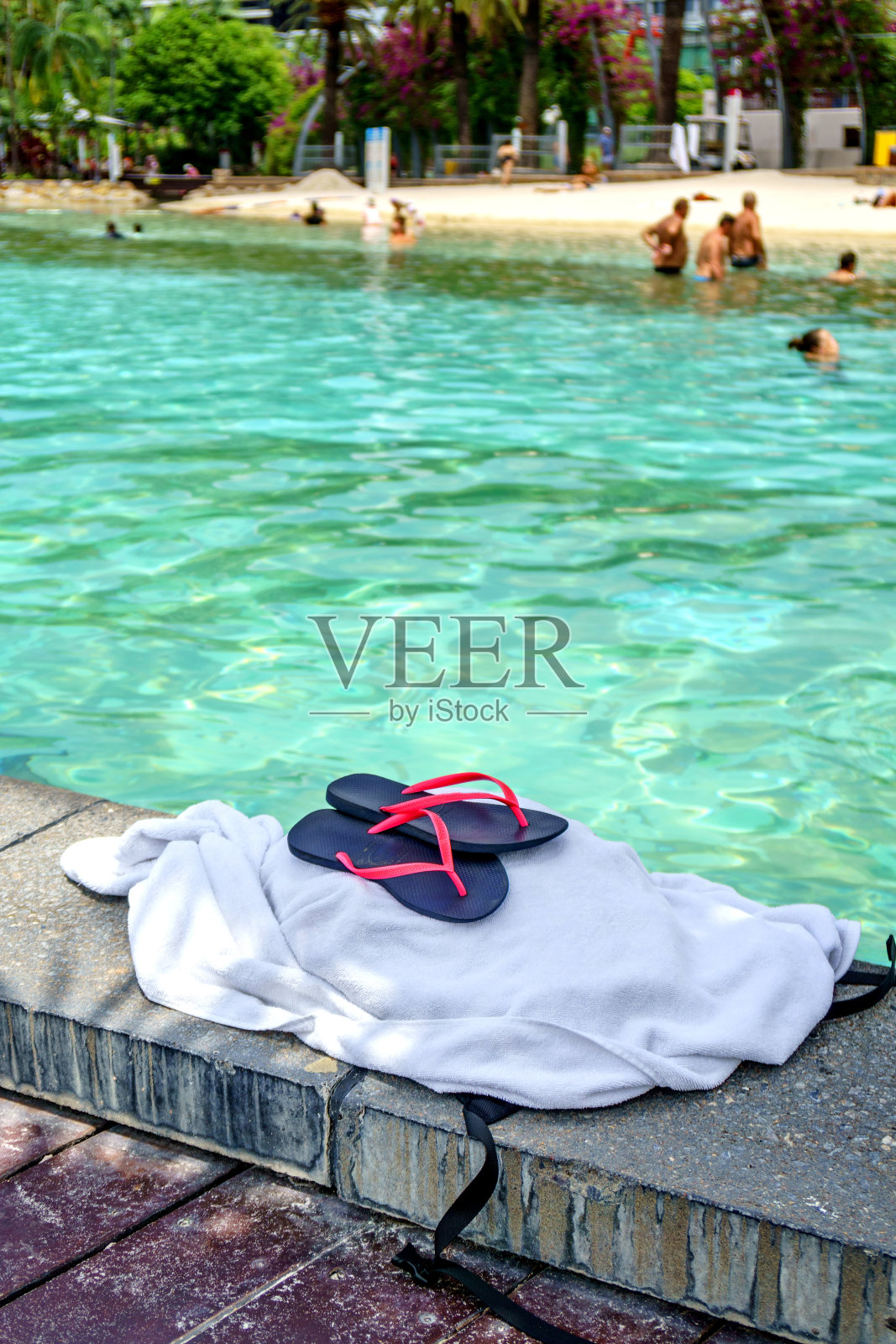 在布里斯班市海滩，人字拖和浴巾泳池边照片摄影图片