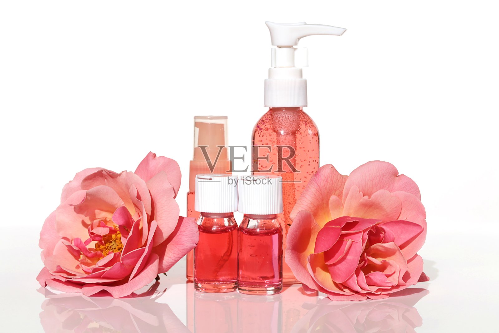 玫瑰提取。玫瑰精华化妆品套装。玻璃安瓿精华液，面部肌肤滋养凝胶，白底玫瑰花。照片摄影图片