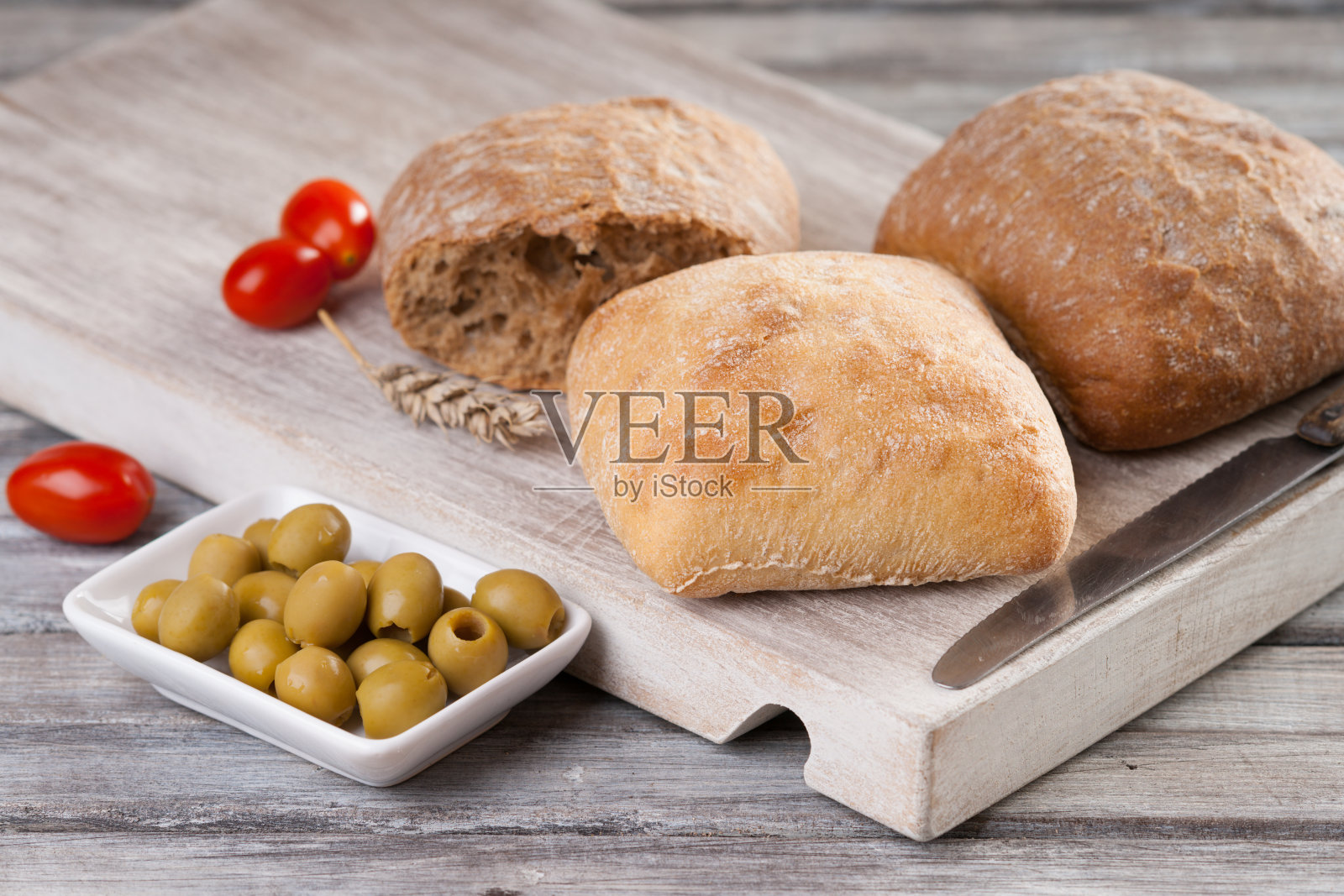 自制面包、番茄、橄榄和刀具照片摄影图片