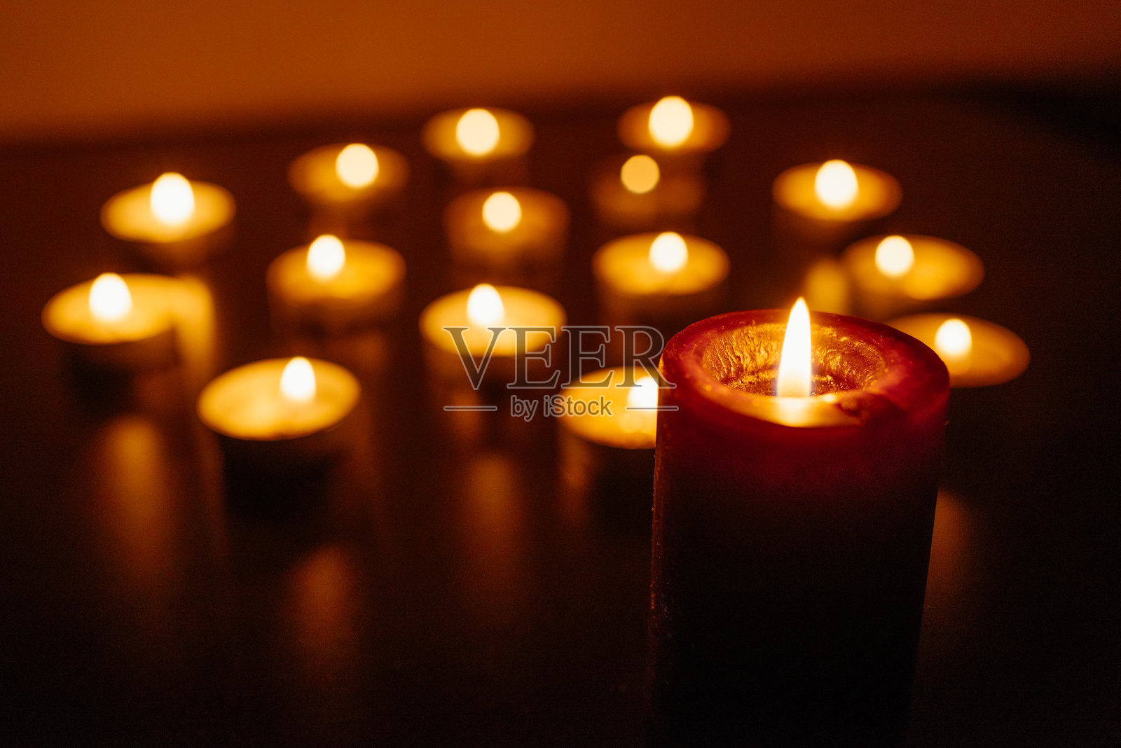 燃烧的蜡烛。景深浅。许多圣诞蜡烛在夜晚燃烧。抽象的蜡烛背景。许多蜡烛火焰在黑暗的背景上发光。特写镜头。自由空间。照片摄影图片