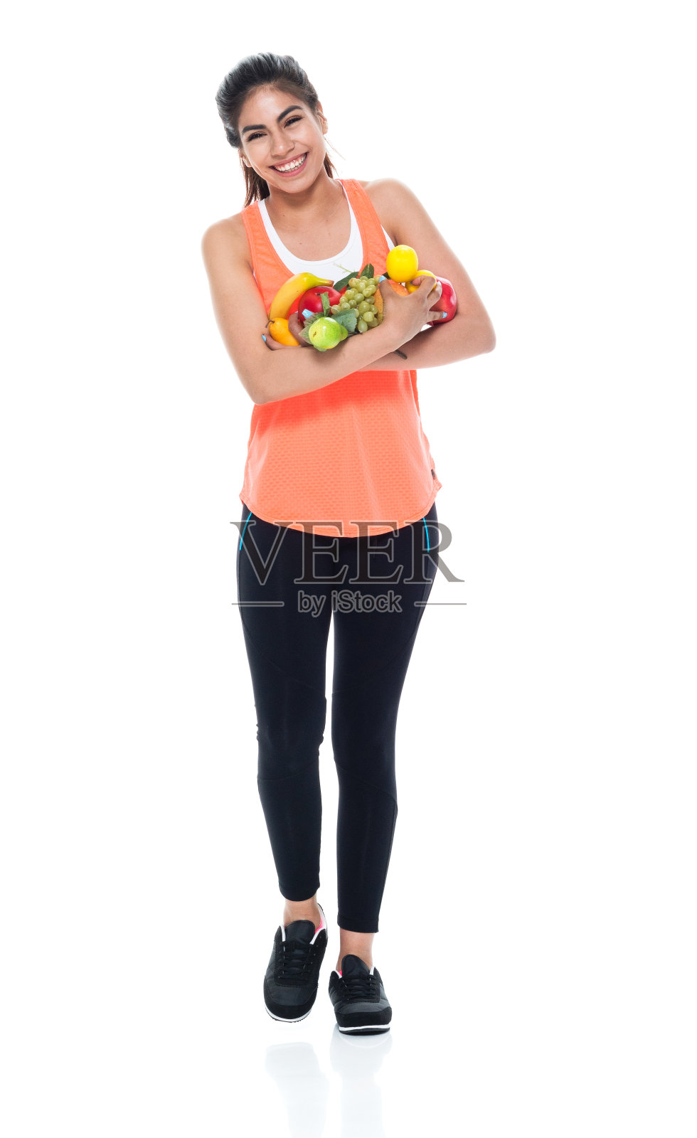 穿着运动服带着水果走路的美女照片摄影图片