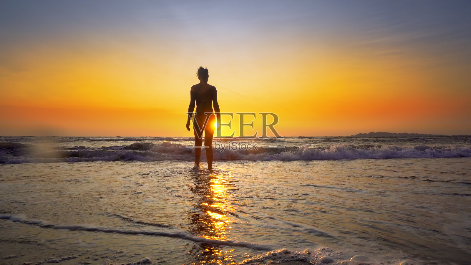 海滩女人在日落享受自由在暑假假期旅行的水。美丽快乐自由的混血儿白种女孩照片摄影图片