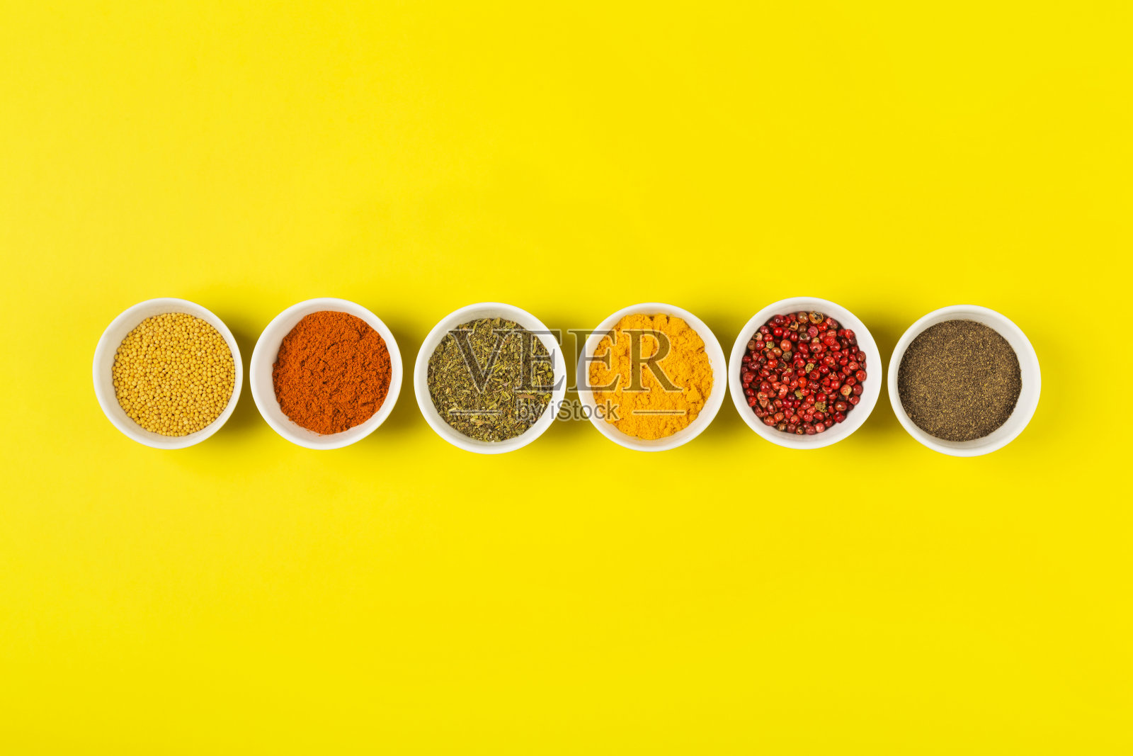 黄色背景碗中的各种香料，顶视图，美食背景照片摄影图片