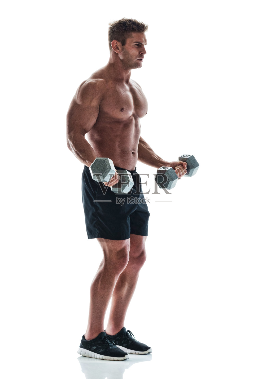 英俊的肌肉男在用哑铃照片摄影图片