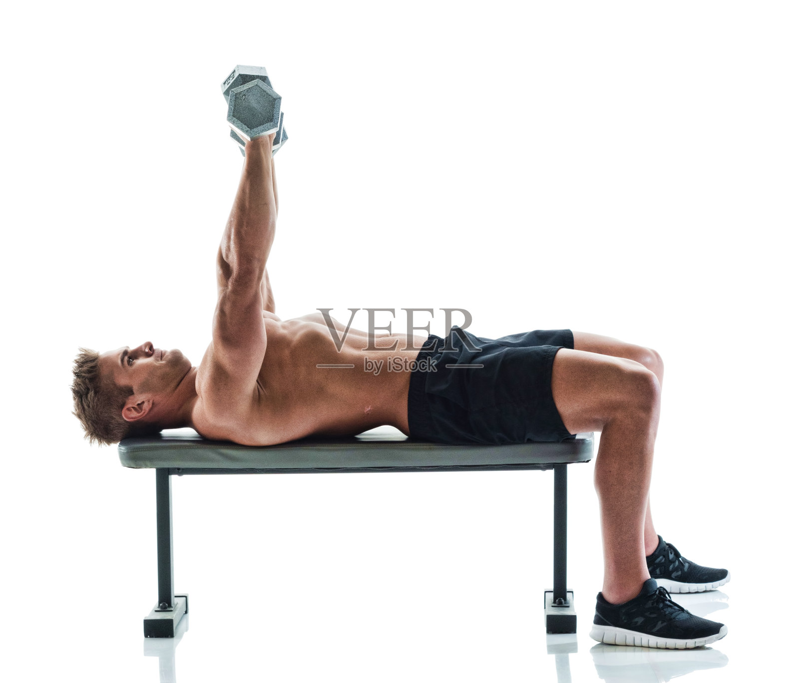 肌肉发达的帅哥在健身长椅上举着哑铃照片摄影图片