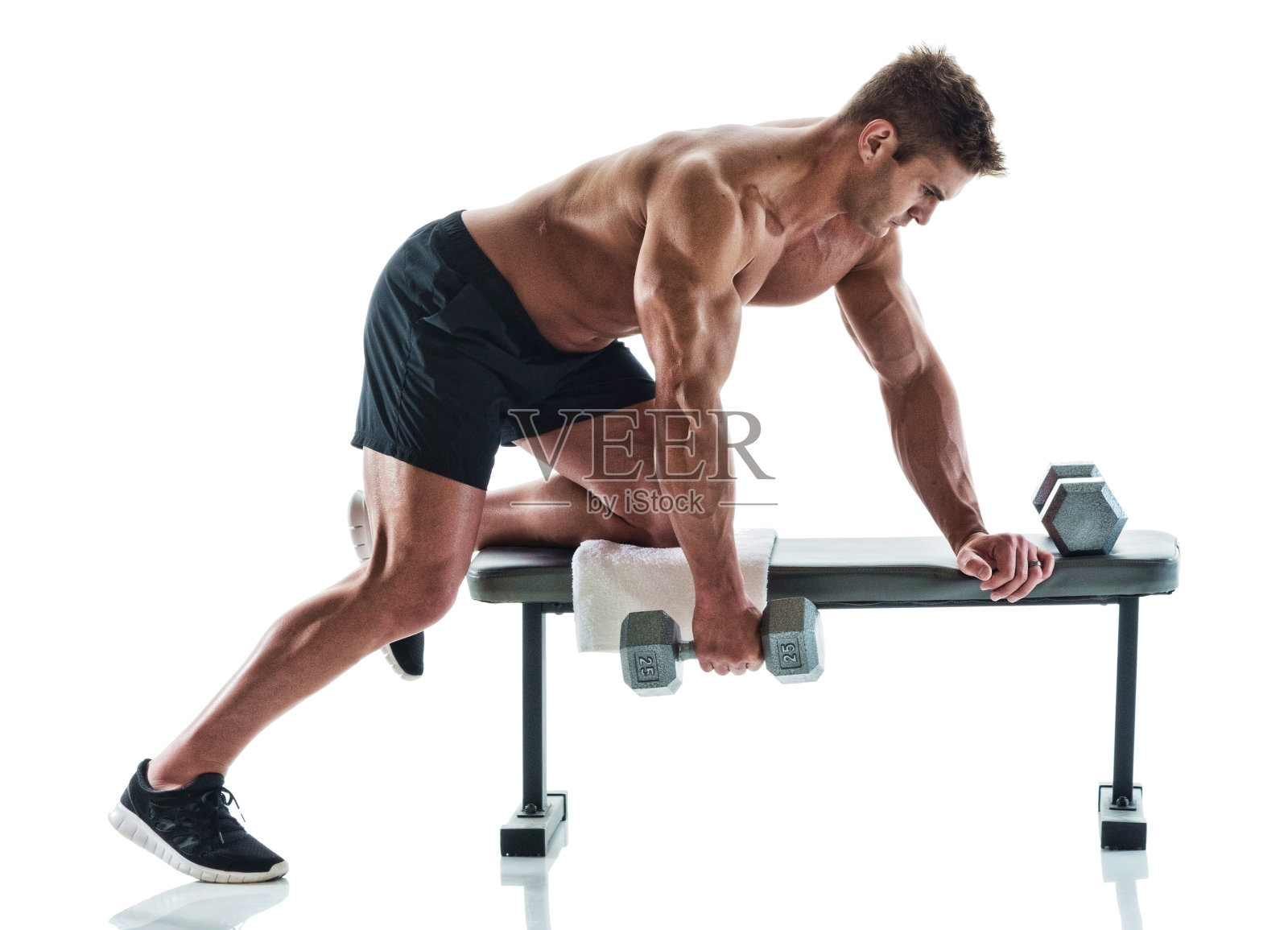 肌肉发达的帅哥在健身长椅上举着哑铃照片摄影图片