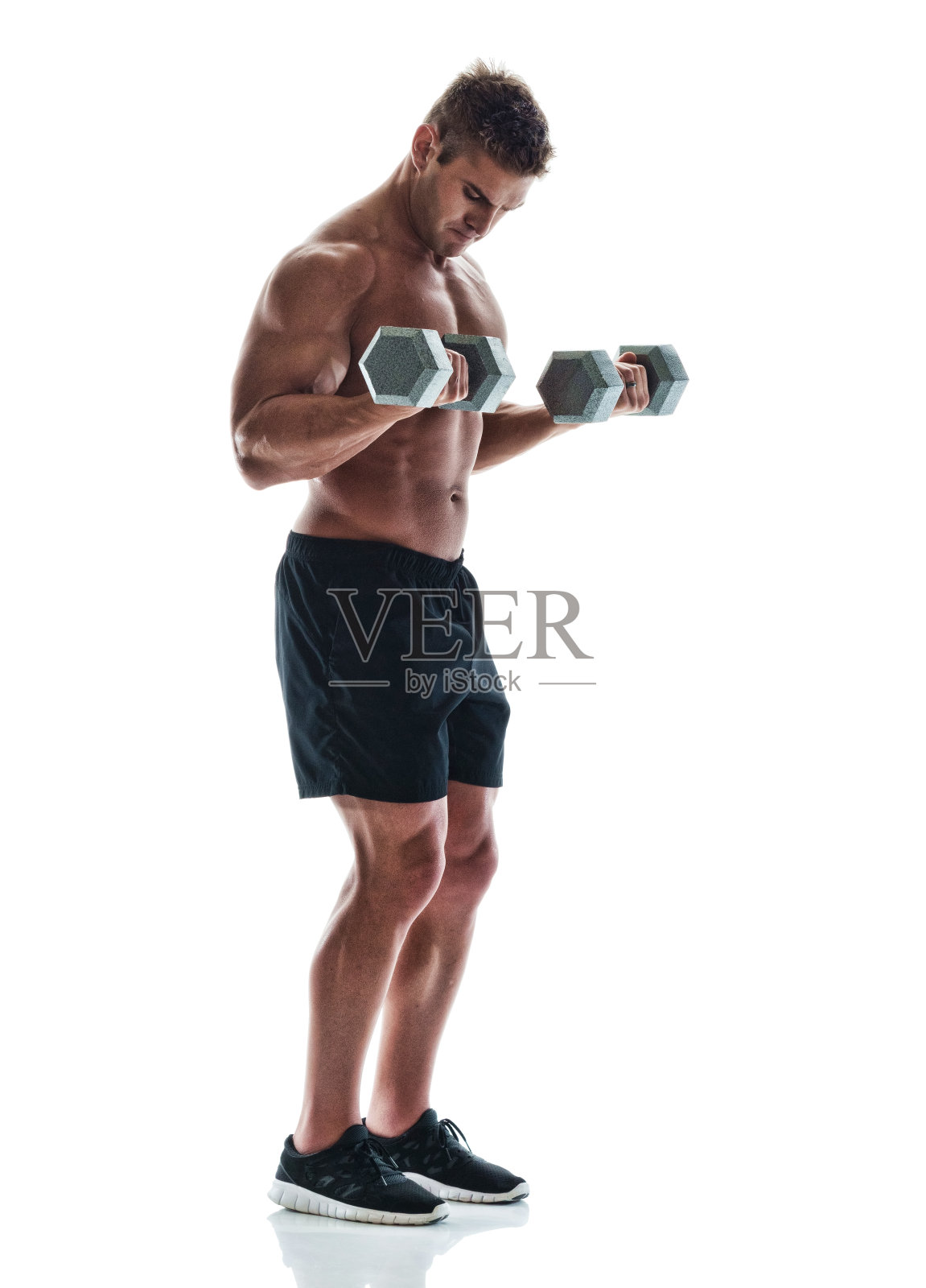 英俊的肌肉男在用哑铃照片摄影图片