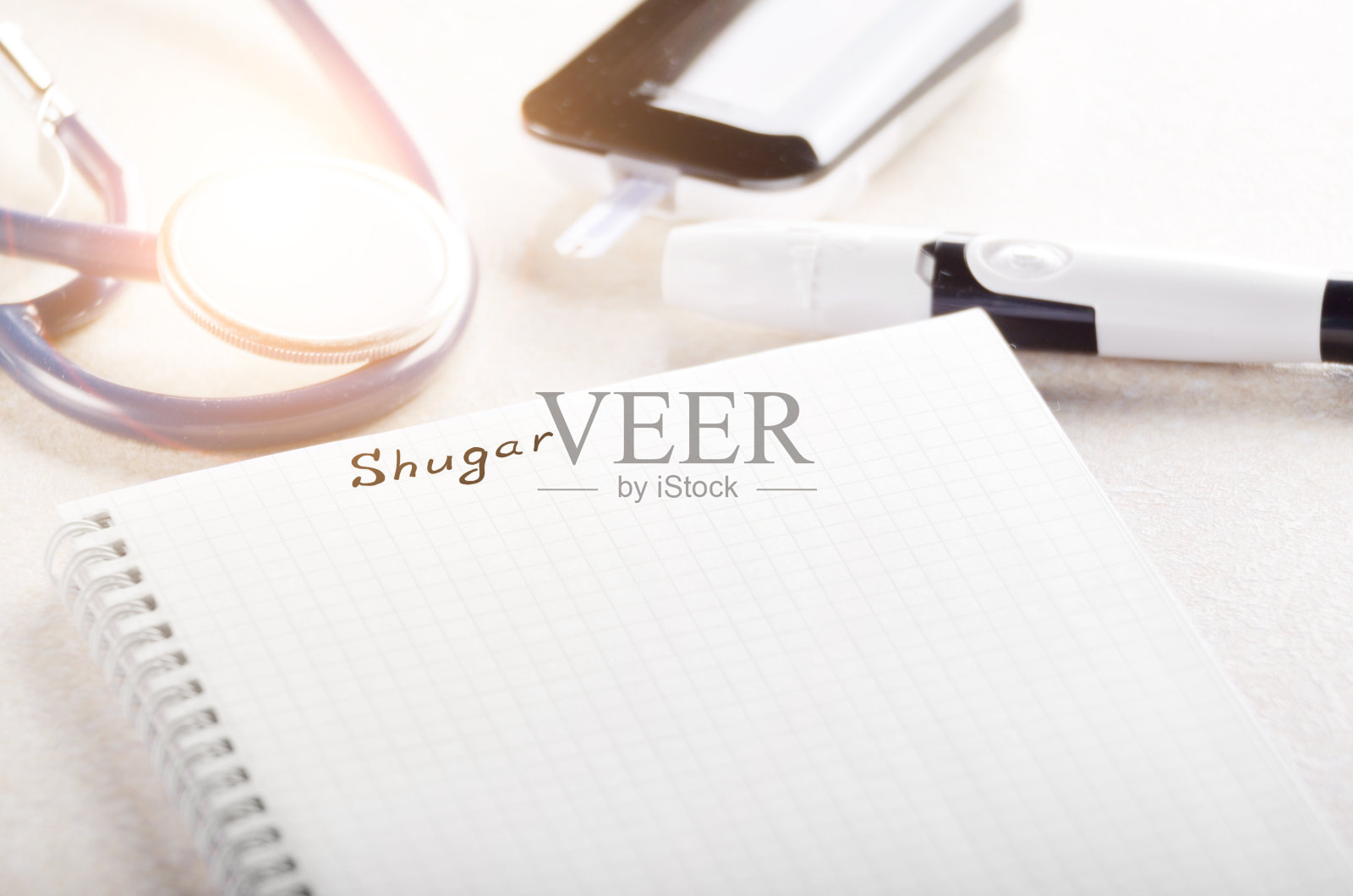 桌上放有个人血糖仪、笔记本和带听诊器的柳叶刀照片摄影图片