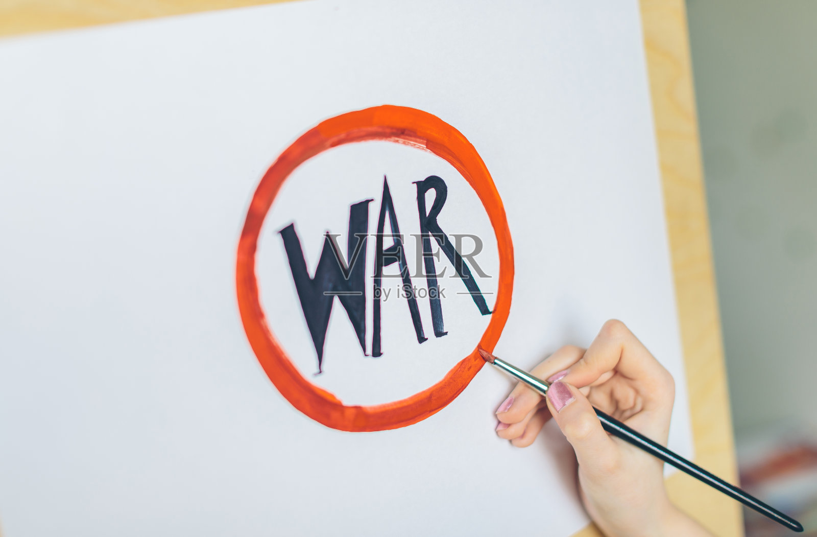 女孩在红圈里写下了“战争”这个词照片摄影图片