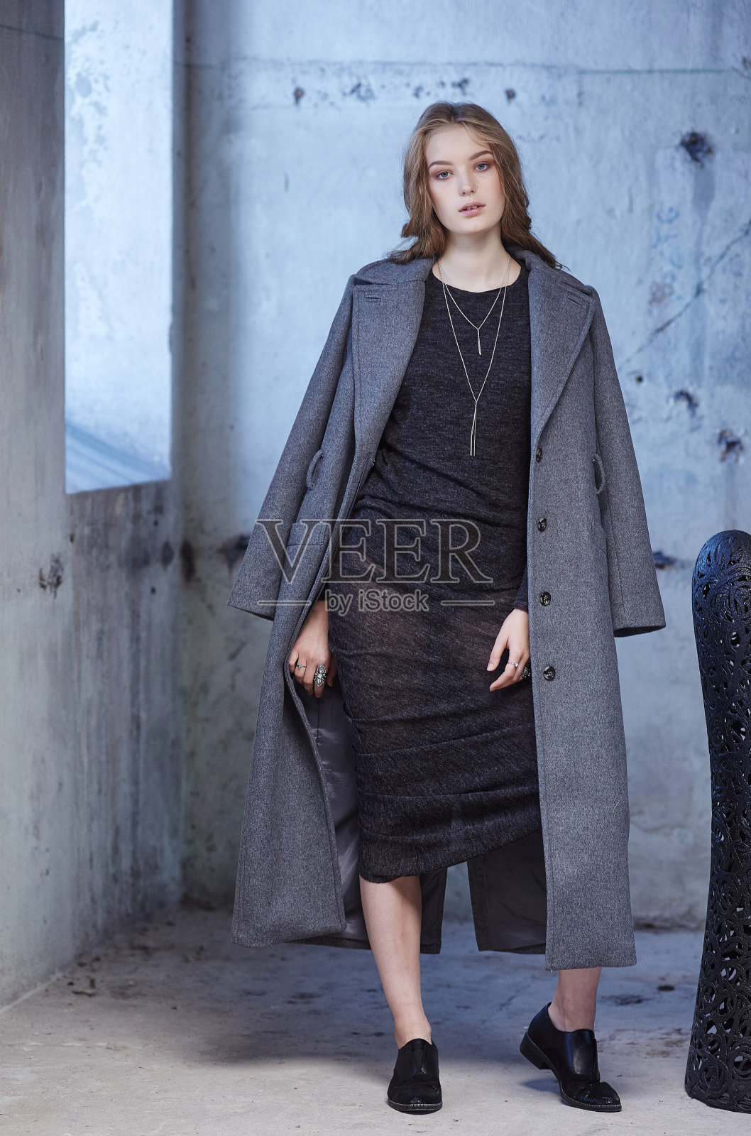 一个穿灰色外套的女人。照片摄影图片