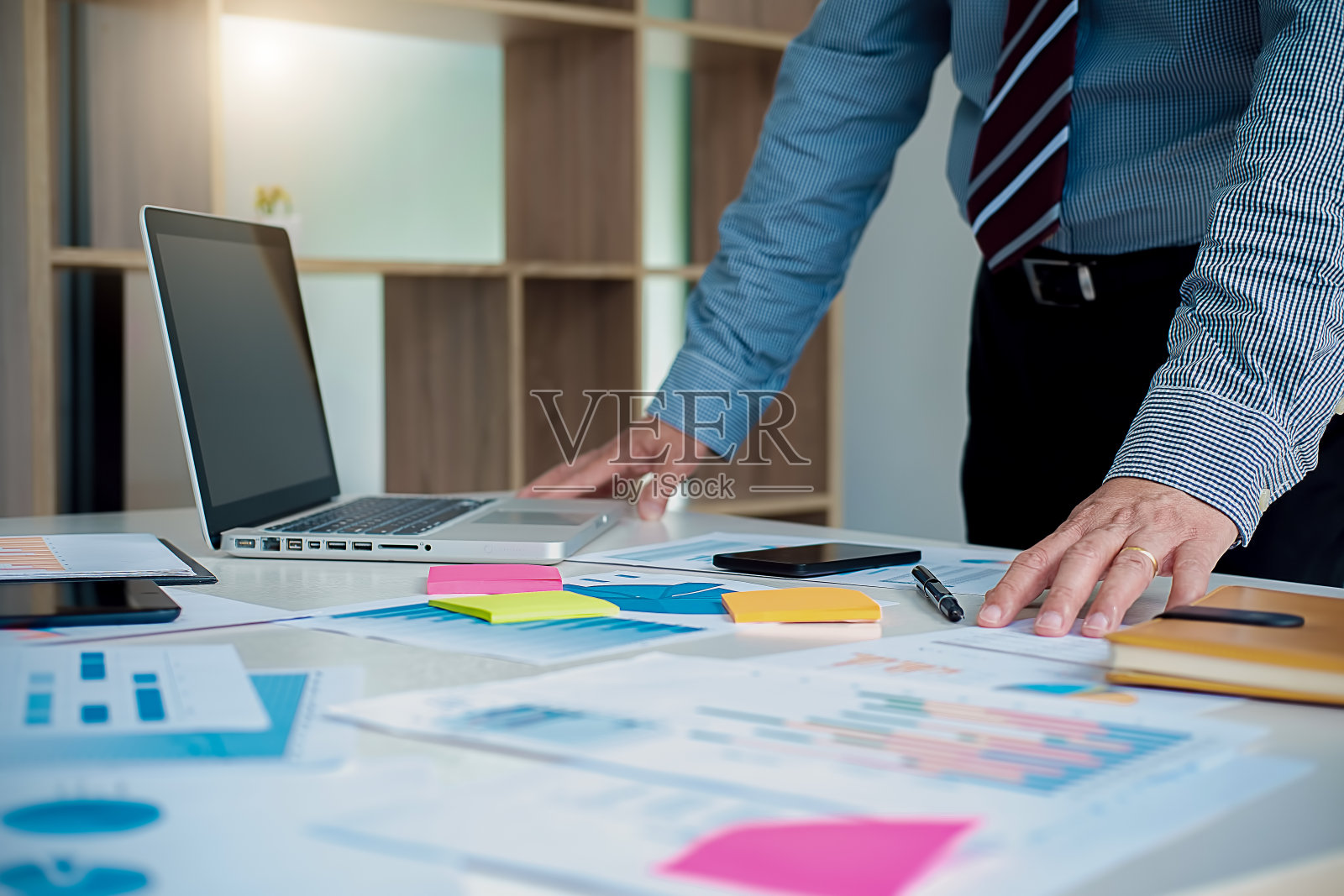 在办公室工作，桌上放着笔记本电脑和文件。经营理念。照片摄影图片