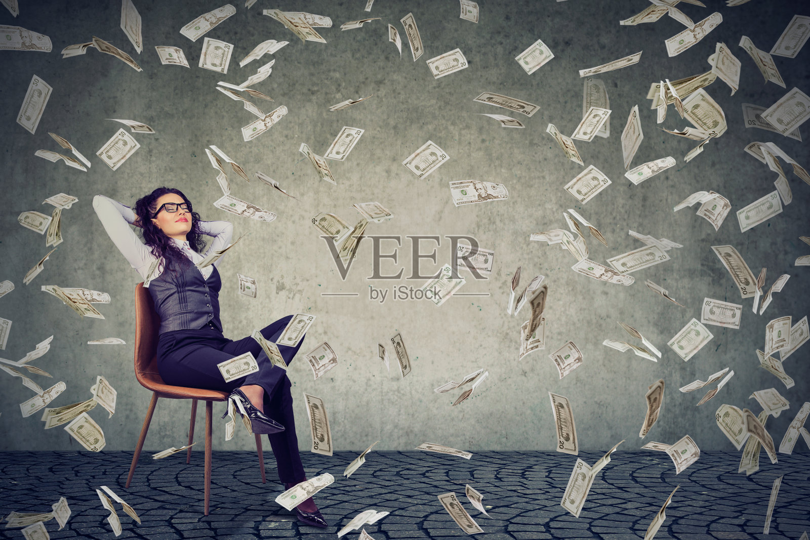 成功女人坐在钱雨下照片摄影图片