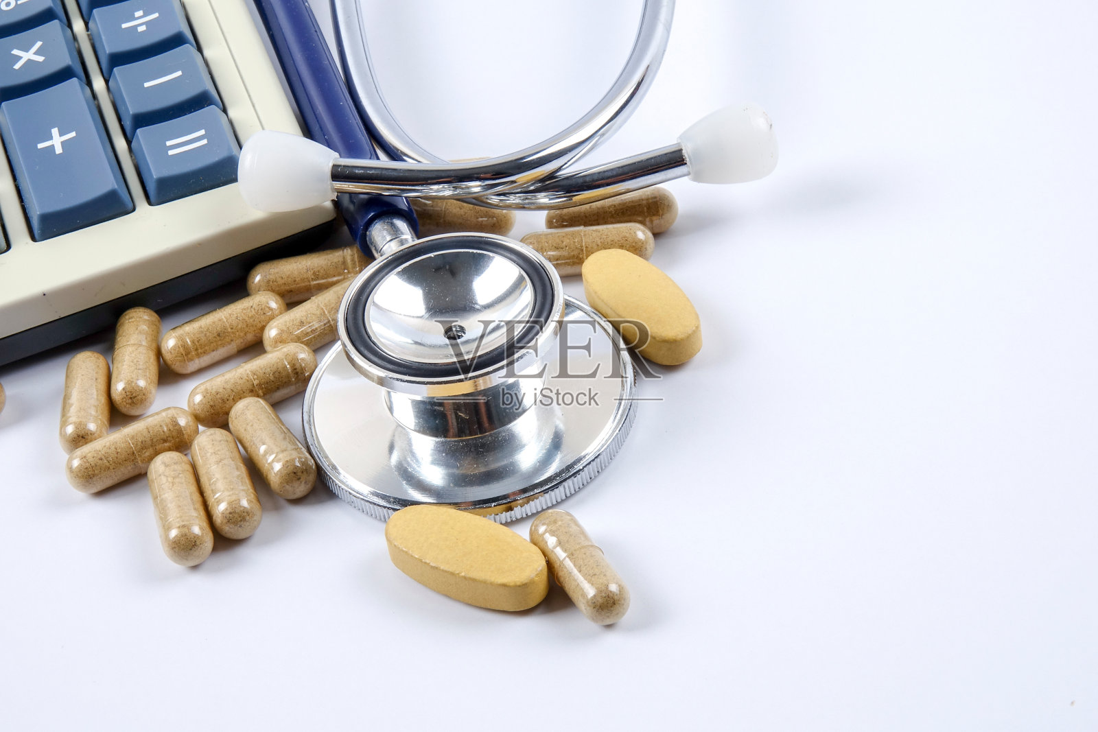 带有计算器和药物的听诊器的特写，在白色背景上照片摄影图片