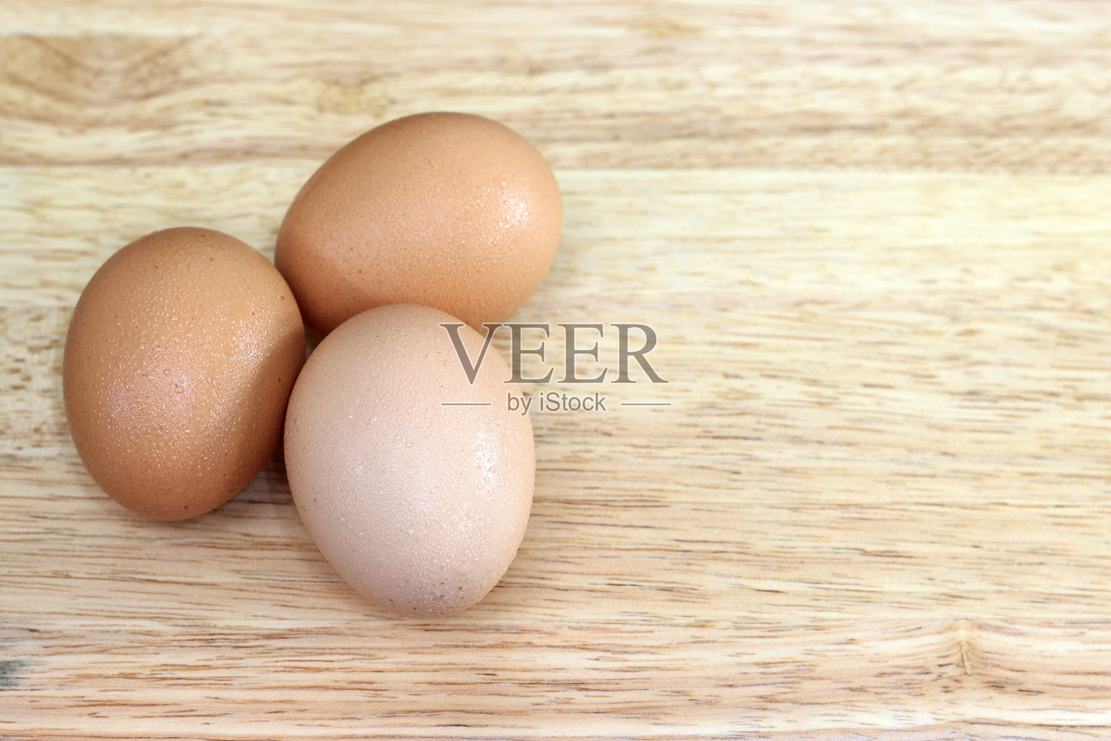 组蛋在木砧板上，蛋在木背景上，食物的概念照片摄影图片