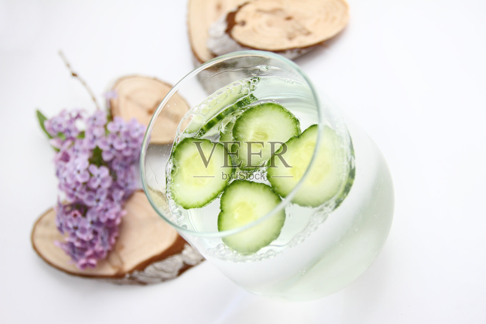 排毒水与黄瓜在白色背景与丁香和木材装饰。健康食品的概念。清爽夏日自制鸡尾酒。副本的空间。没有提高。抗压力喝。照片摄影图片