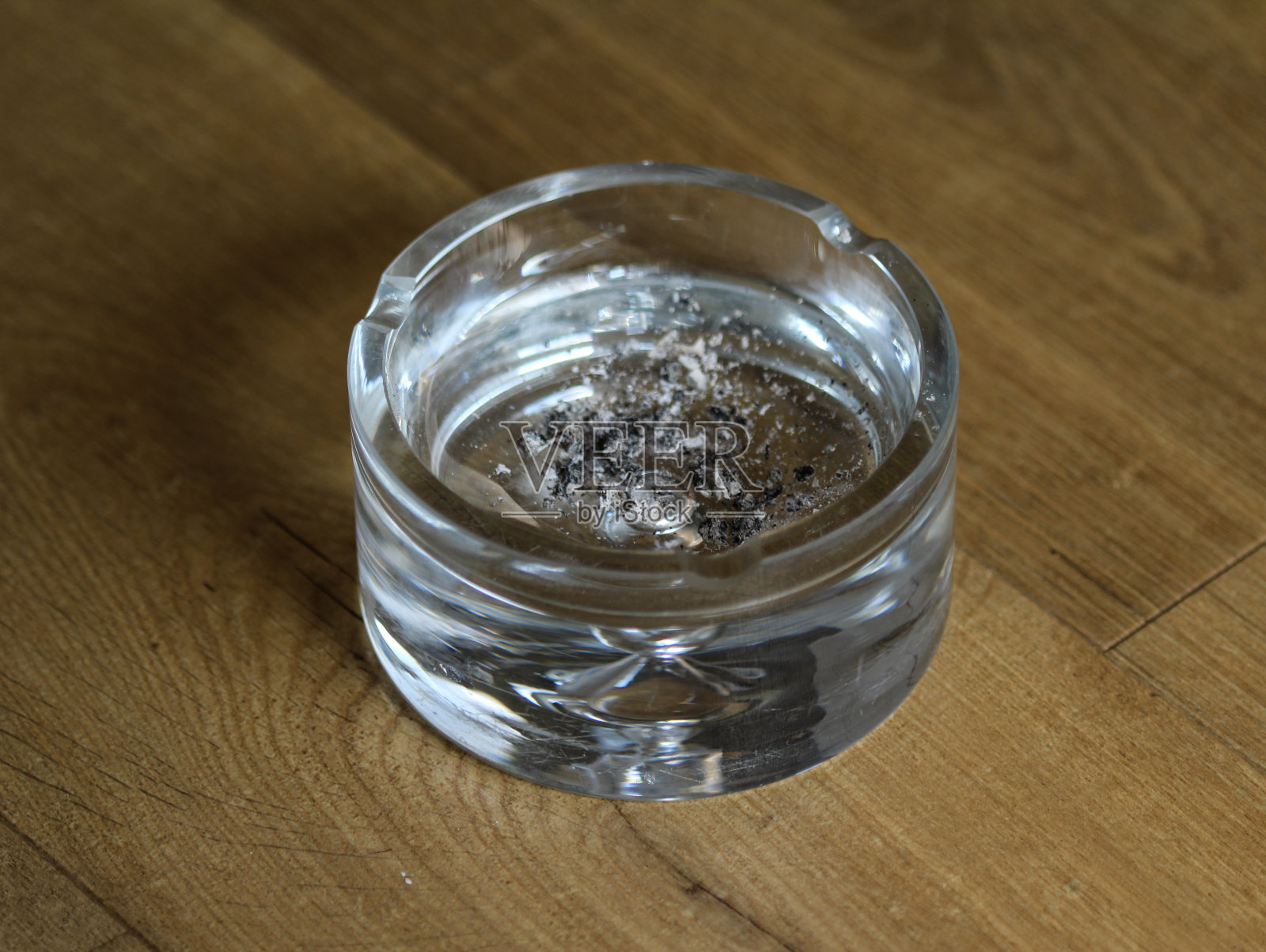 木制背景上的脏玻璃烟灰缸照片摄影图片