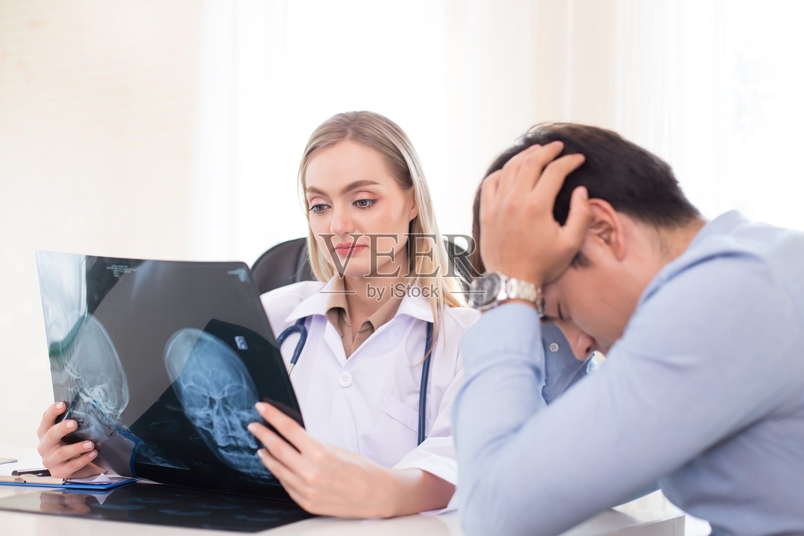 迷人的女医生在诊所向病人展示x光片。医疗保健理念。照片摄影图片