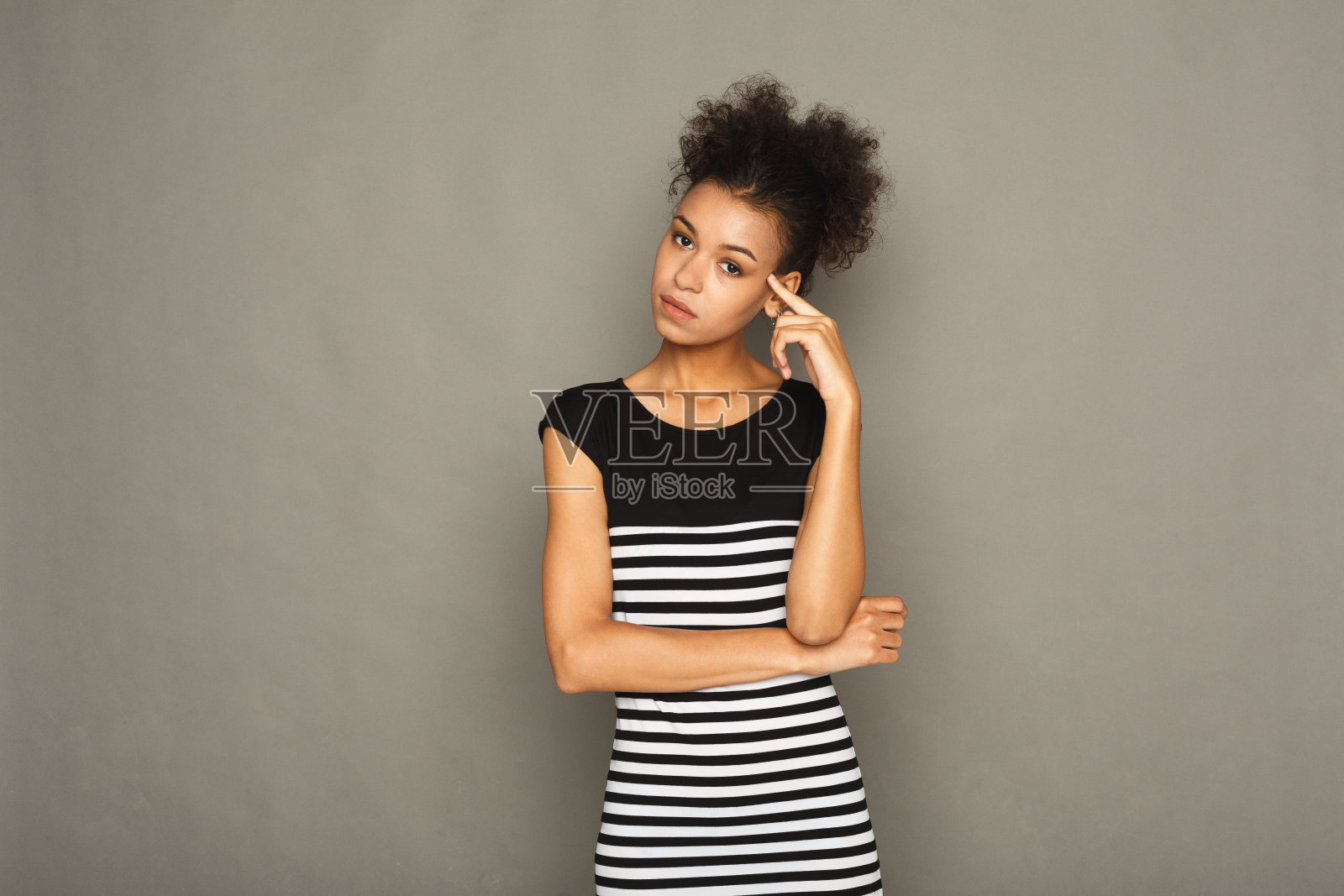 年轻的女人在灰色的背景上拍摄头像照片摄影图片