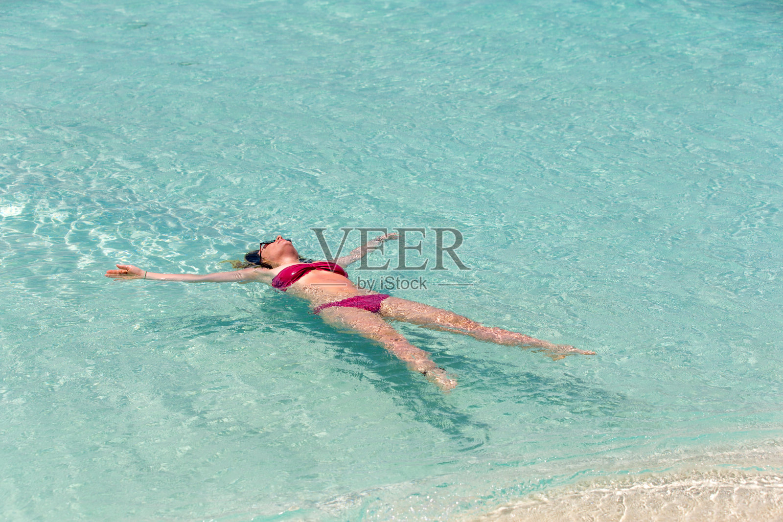 在热带岛屿上漂浮的年轻女子照片摄影图片