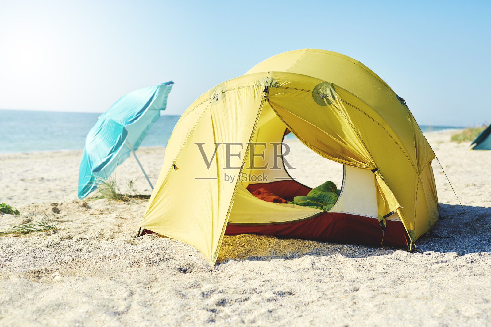 阳光明媚的一天，海滩上搭着黄色的帐篷照片摄影图片